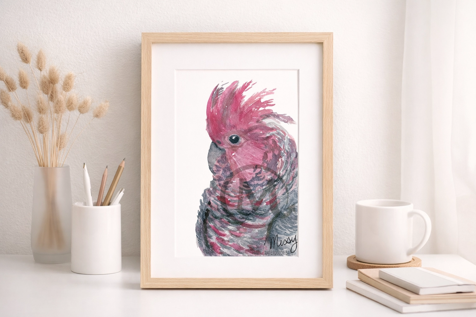 Missy’s original bird watercolor artwork placed inside a minimalist light wood desk frame mockup with Missy’s watermark and signature fully visible.