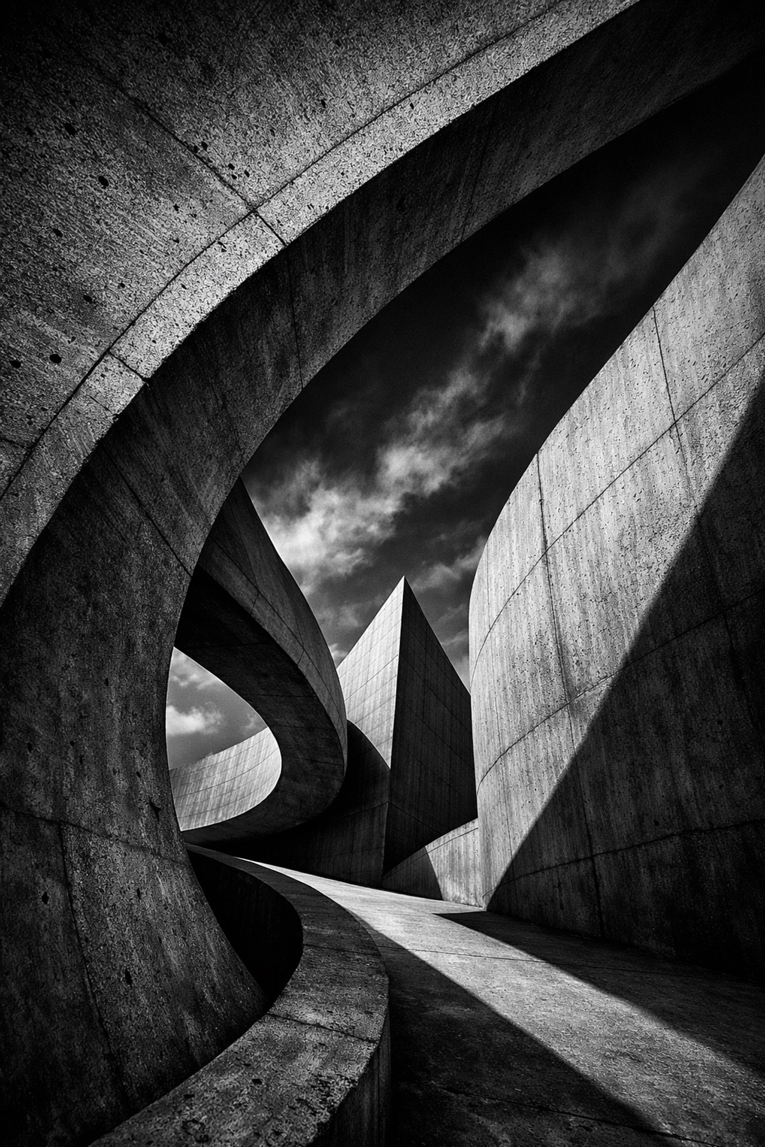 Dramatic black and white fine art photography of modern architectural curves and shadows.