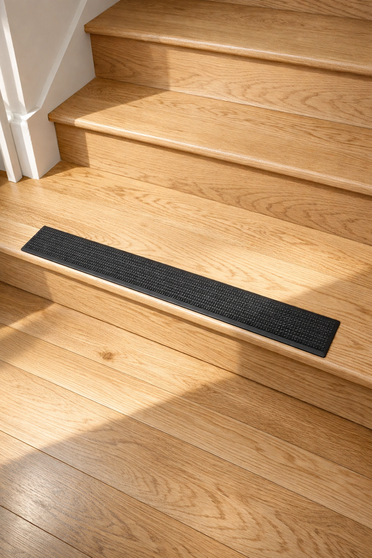 Contrasting anti-slip tread on the bottom stair step to improve visibility and prevent tripping.