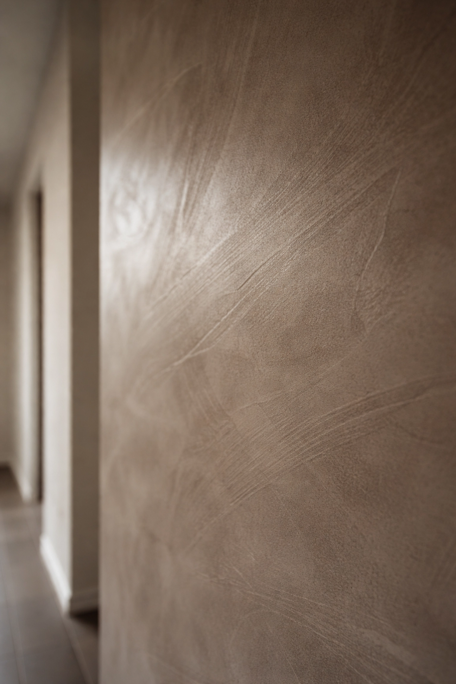 Close-up of hand-burnished plaster wall in a modern basement suite, showcasing texture and depth for luxury renovations.