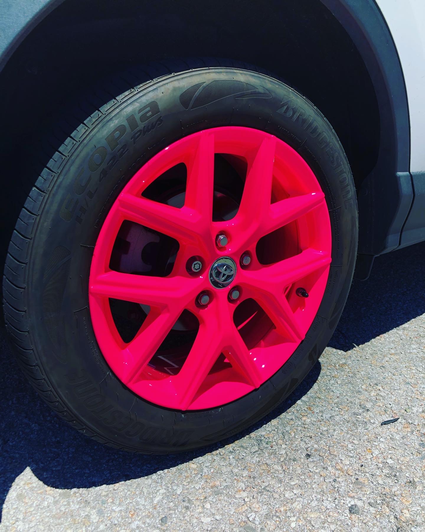 Neon pink powder-coated wheel showing bold color options made possible by proper sandblasting and prep