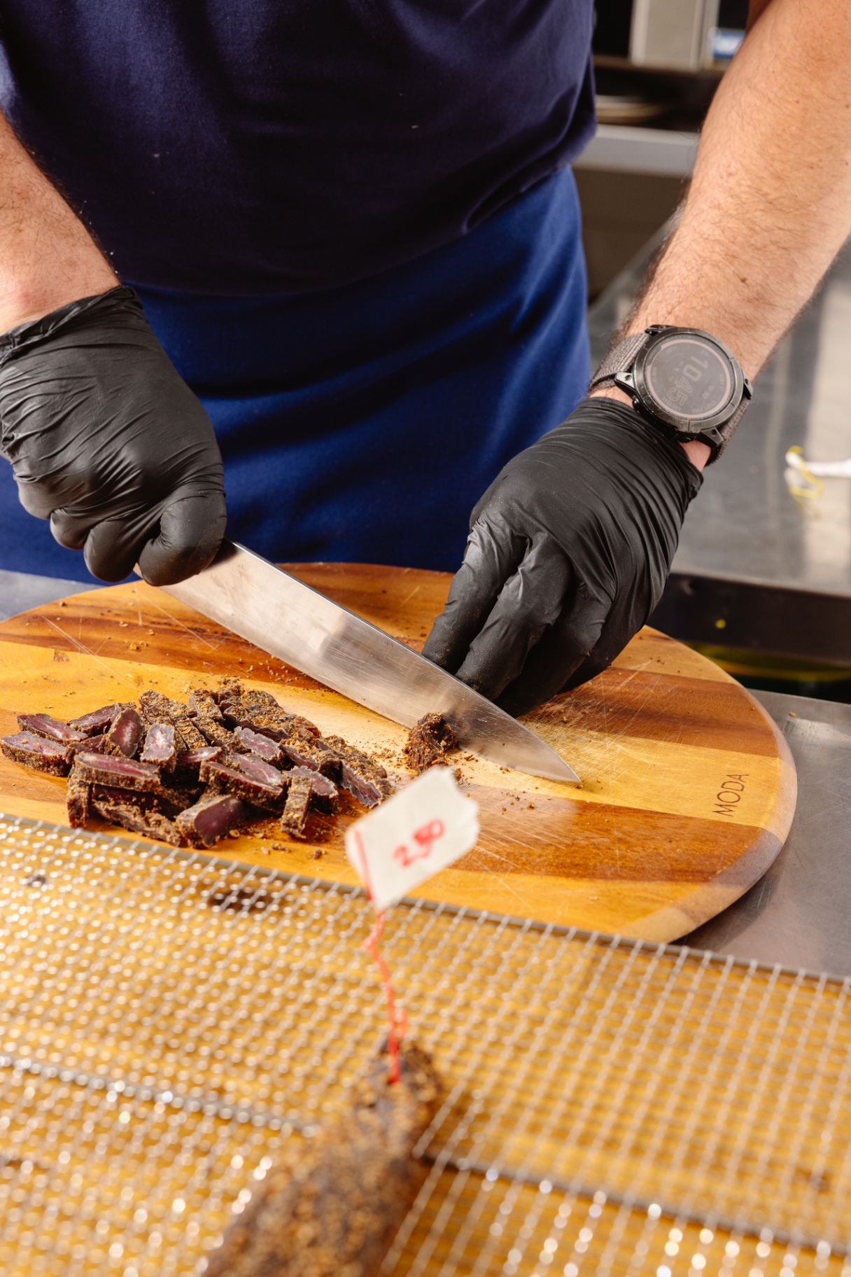 Chef Mark slicing freshly made Australian grass fed beef biltong on wooden cutting board