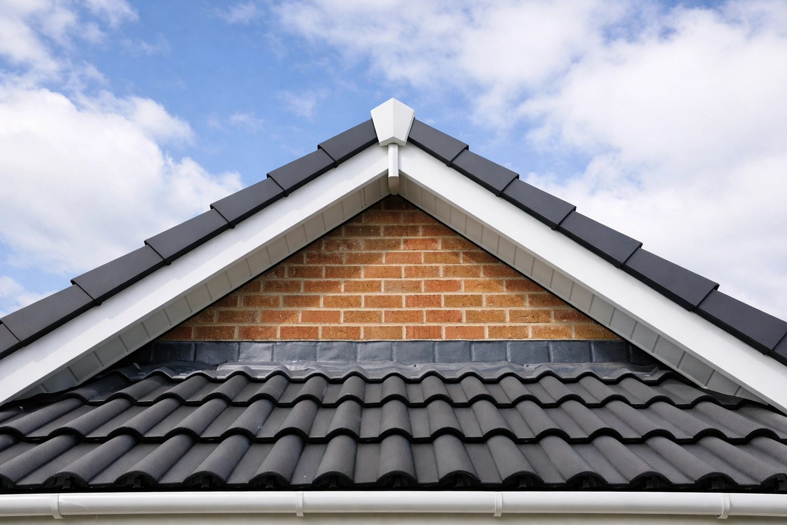 Residential roof gable end with white dry verge system protecting tile edges