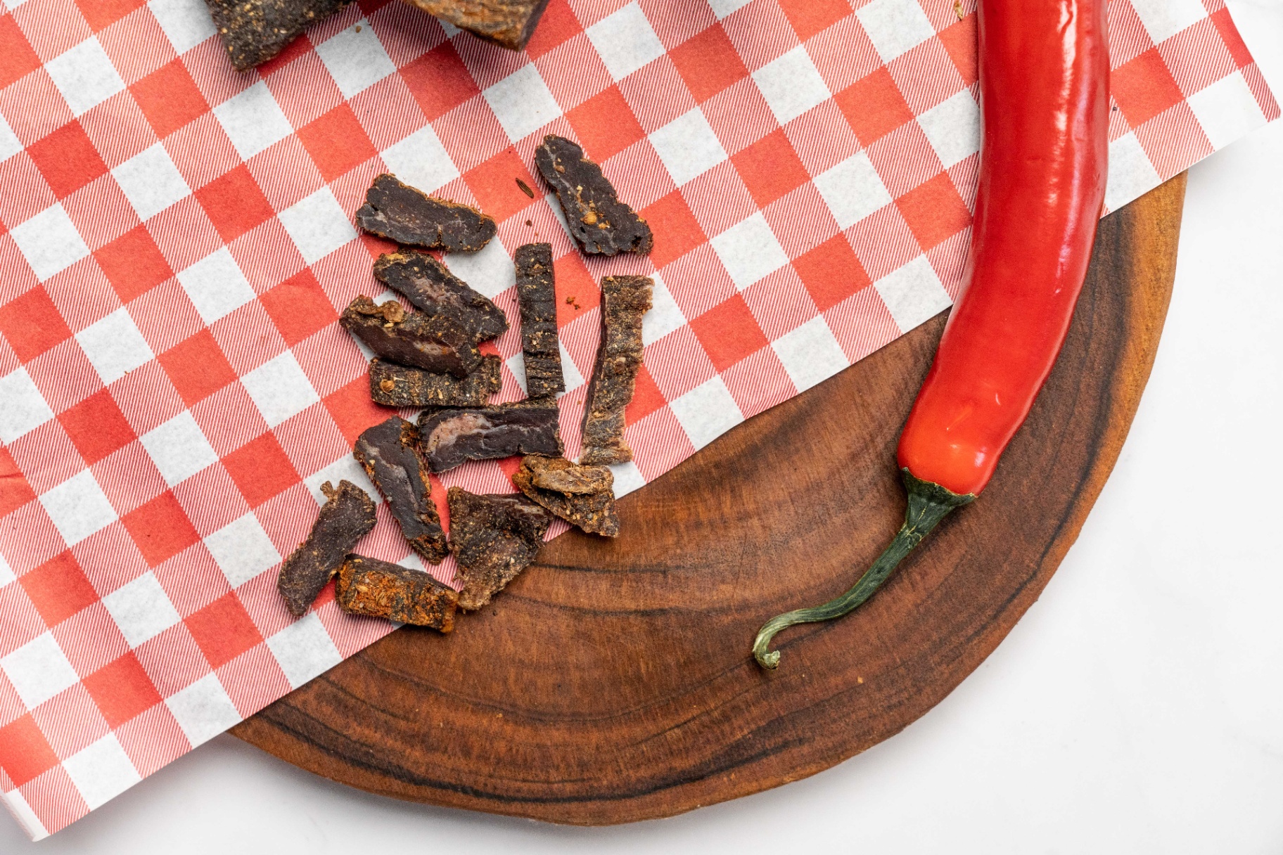 Paprika biltong on wooden board, air dried beef with natural spices, high protein snacks, biltong snacks, biltong nutrition