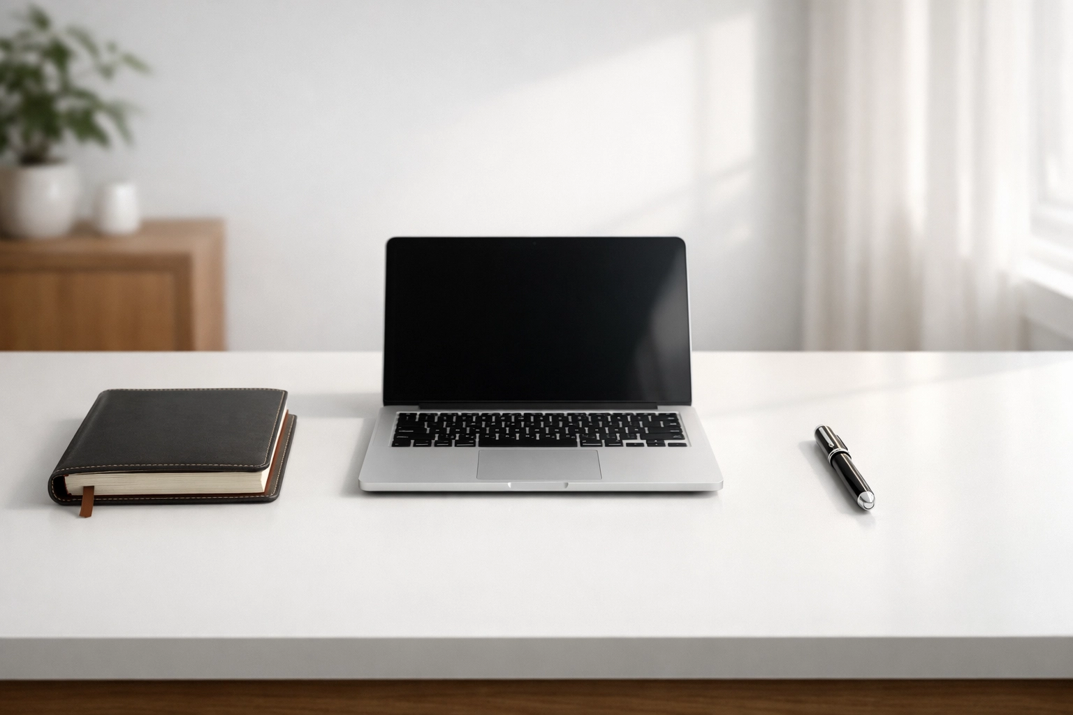 Modern office desk with a laptop and notebook representing scaled ERO practice infrastructure.