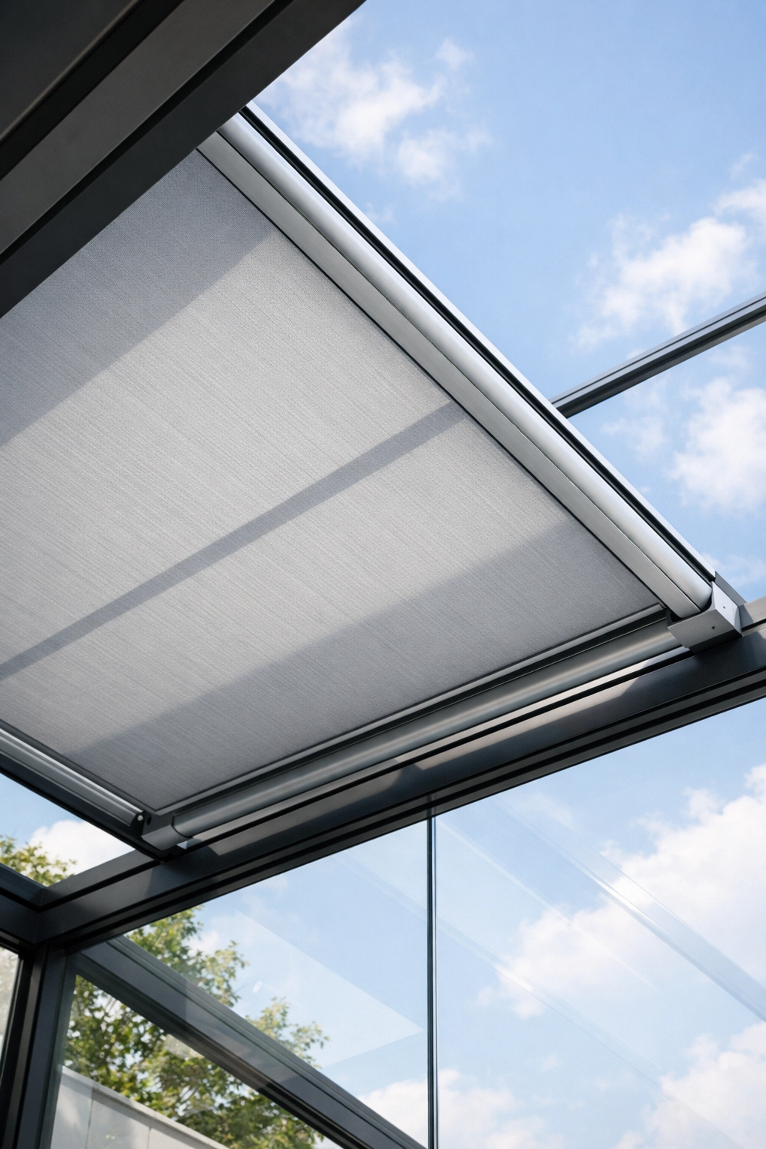 Elektrische Aufglasmarkise auf einer Terrassenüberdachung aus Glas für effizienten Hitzeschutz.