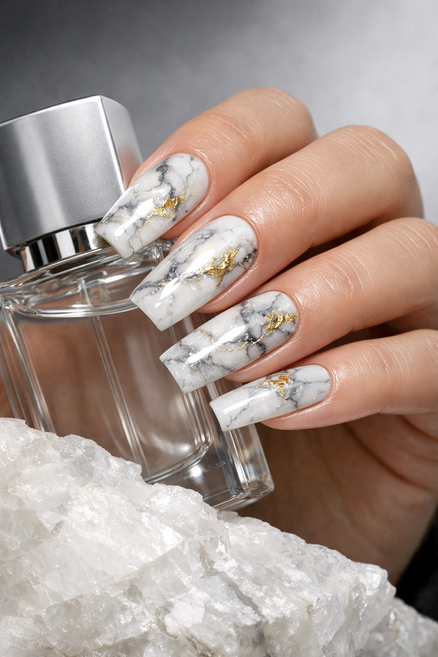 White Carrara marble nails with gold leaf accents, a top choice for fashion nails in Norwood MA.