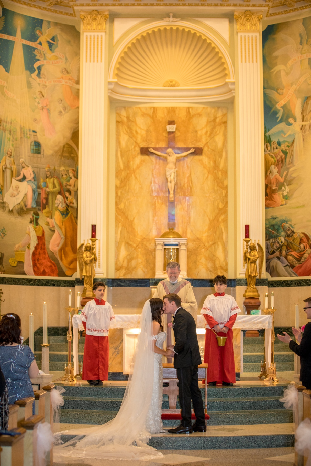 Leighanna and Brian share their first kiss at the altar—framed by ornate church art and golden detail