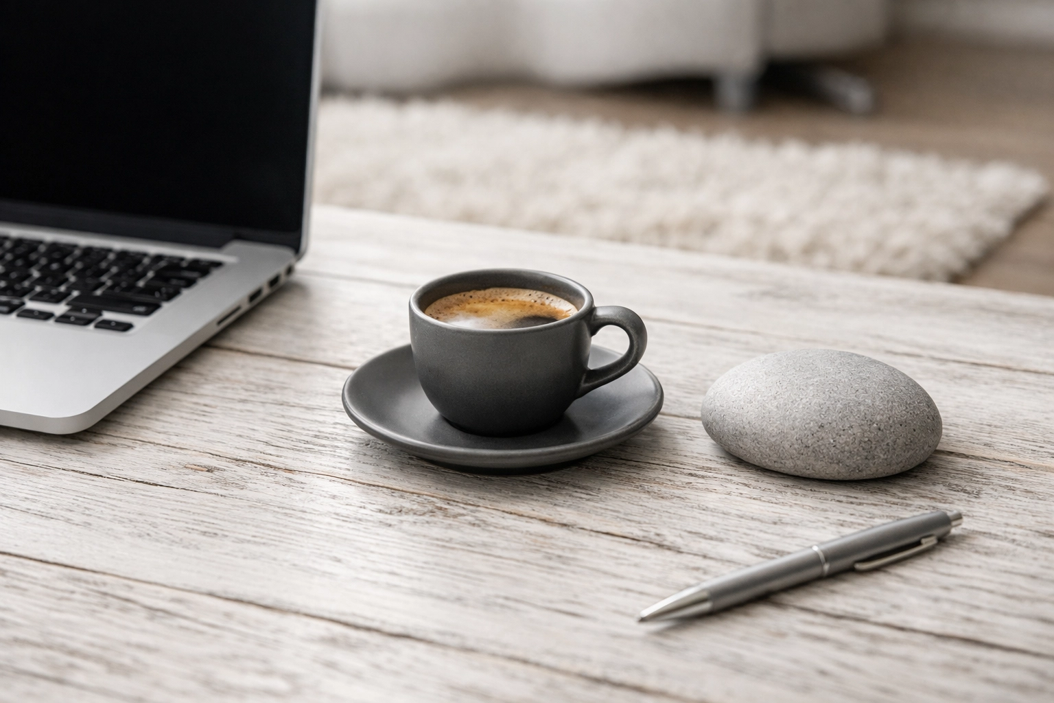 Detailed view of a weathered white desk surface with laptop and minimalist executive office decor.