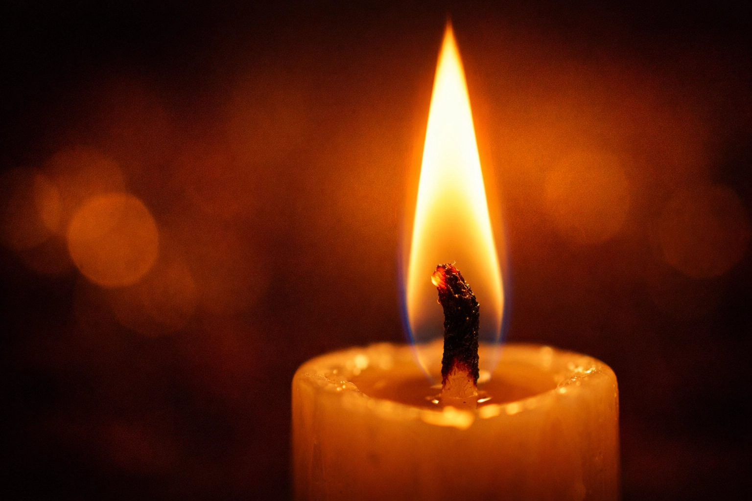 A single candle flame burning brightly, representing stillness and quiet prayer in God.