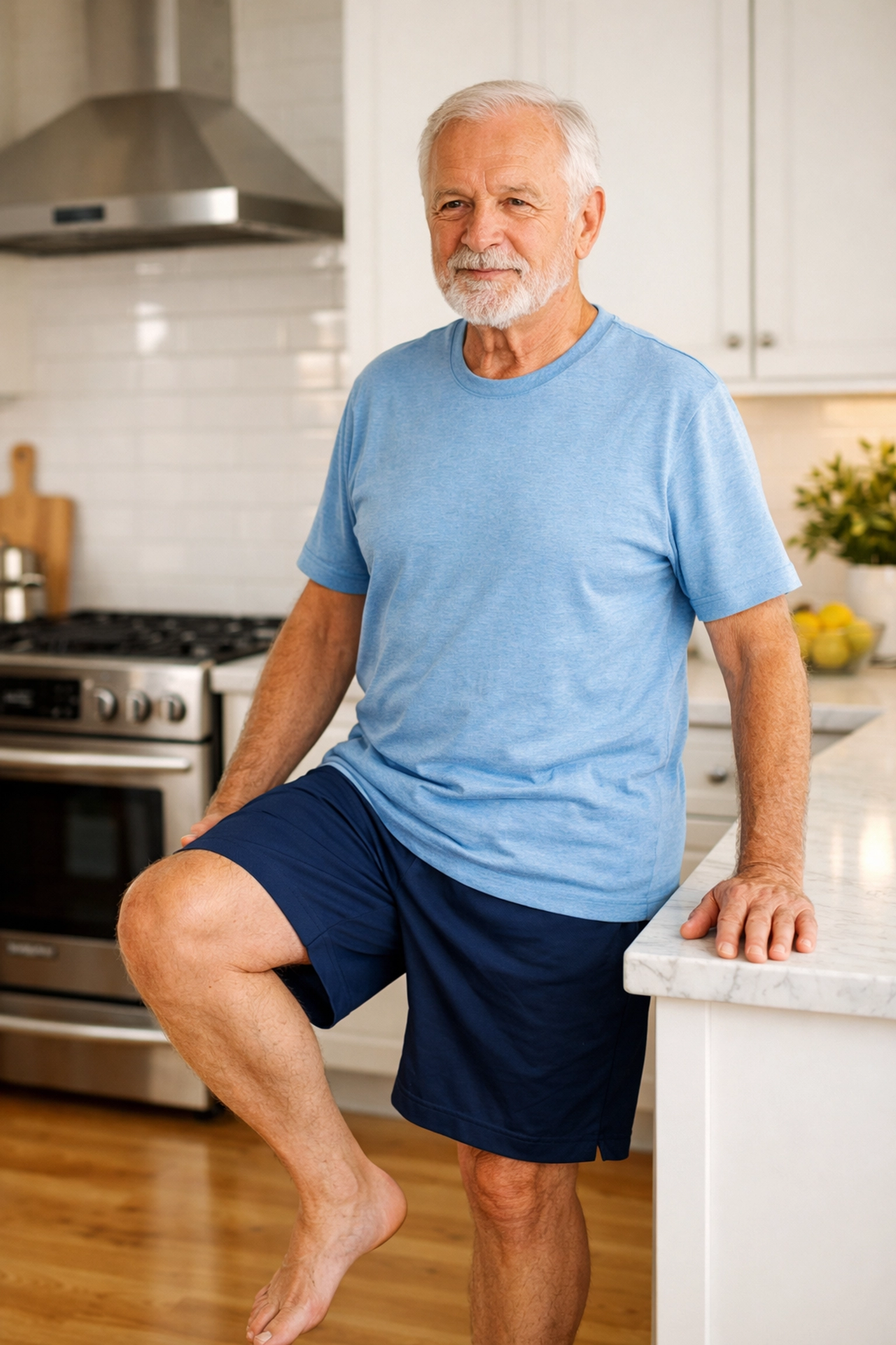 A senior man practicing a single-leg balance exercise using a kitchen countertop for stability.