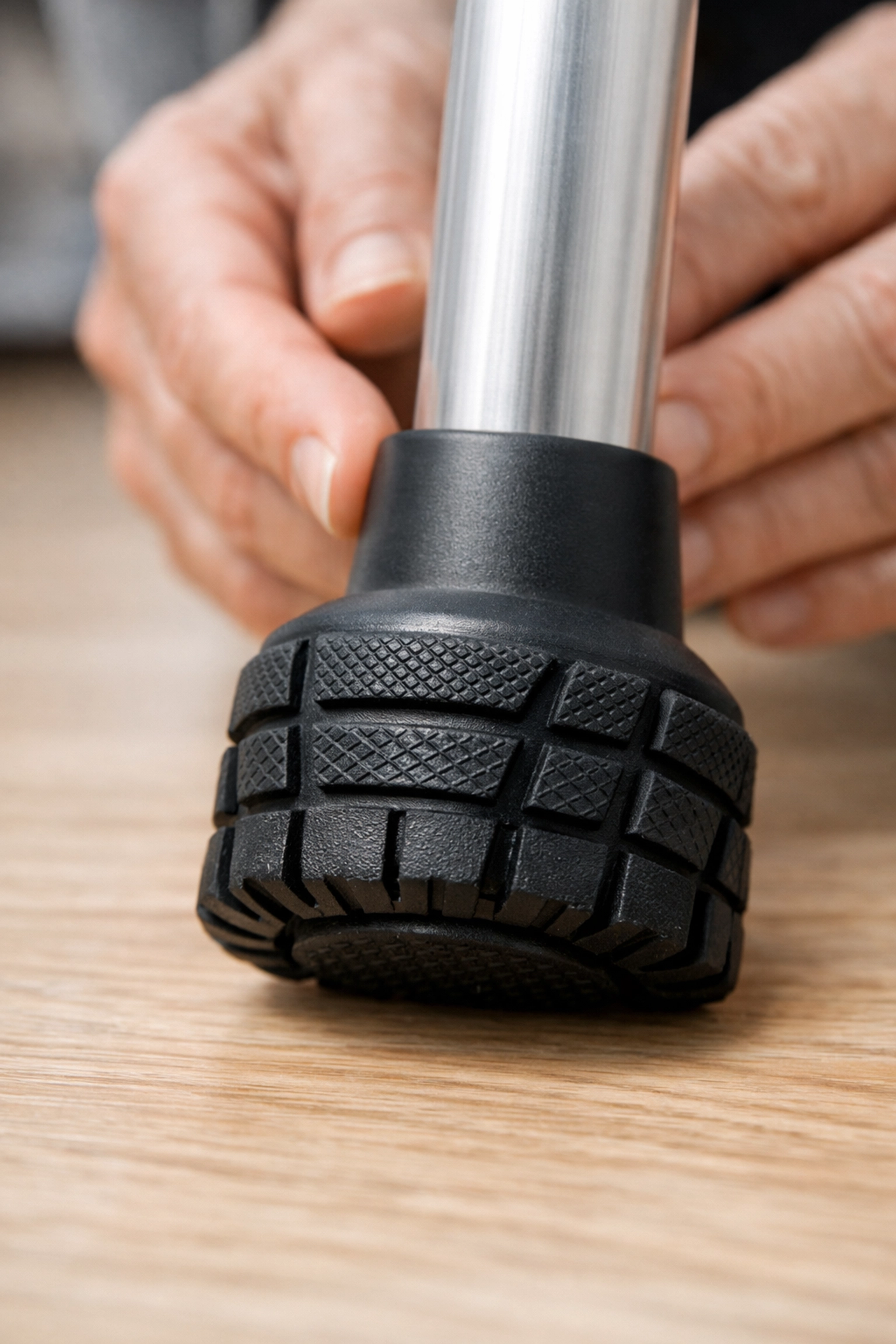 Close-up of a new walker rubber tip with deep treads to prevent slips on hardwood floors.