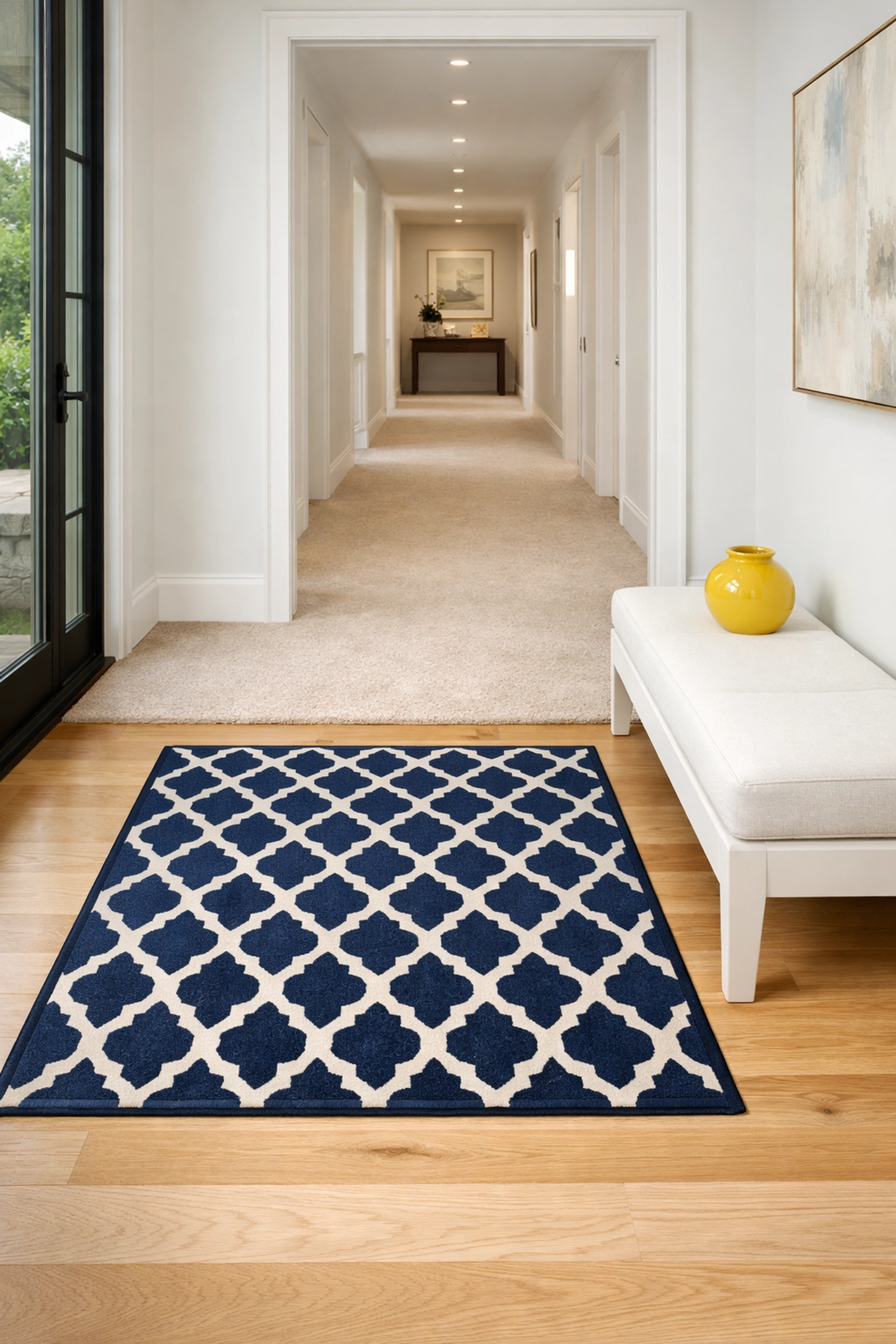 A clean luxury entryway with a rug and bench, helping to prevent outdoor dirt from reaching indoor carpets.