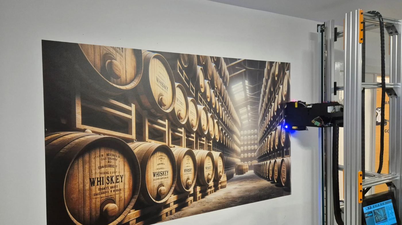 Photorealistic mural of stacked whiskey barrels inside a distillery, printed directly on a white interior wall