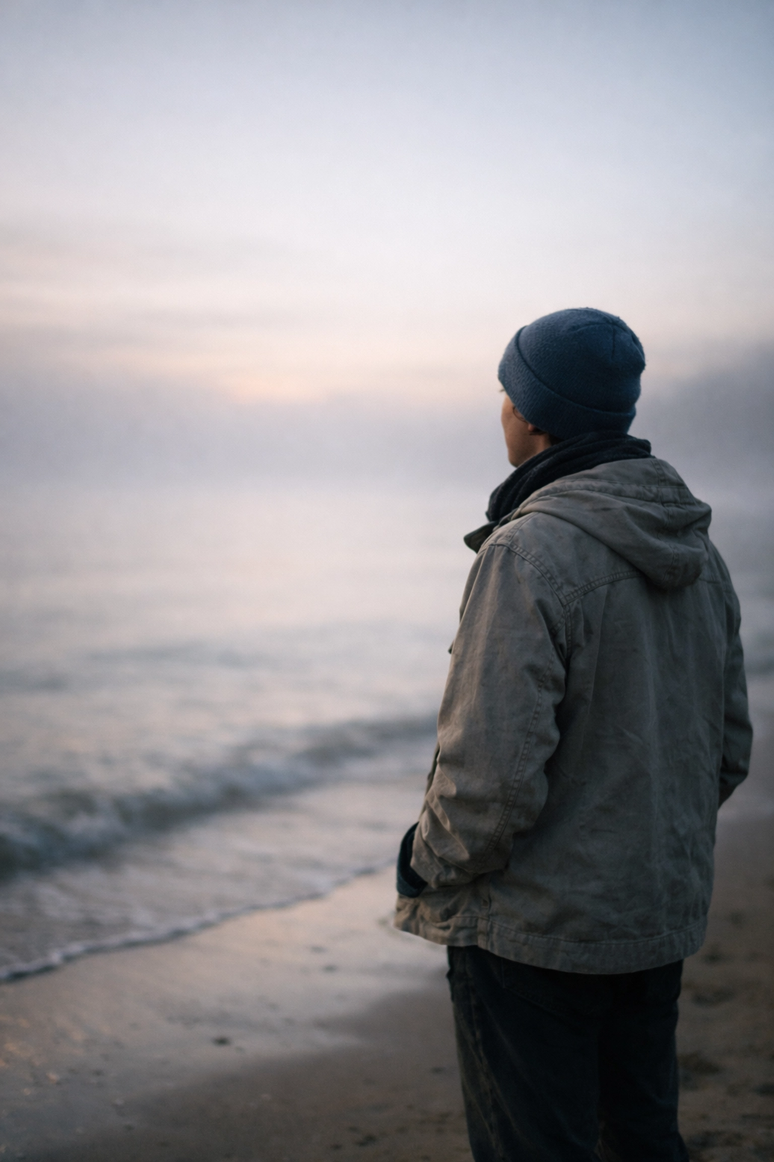 A calm person on a misty shoreline at dawn, representing internal self-approval and the end of seeking external validation.