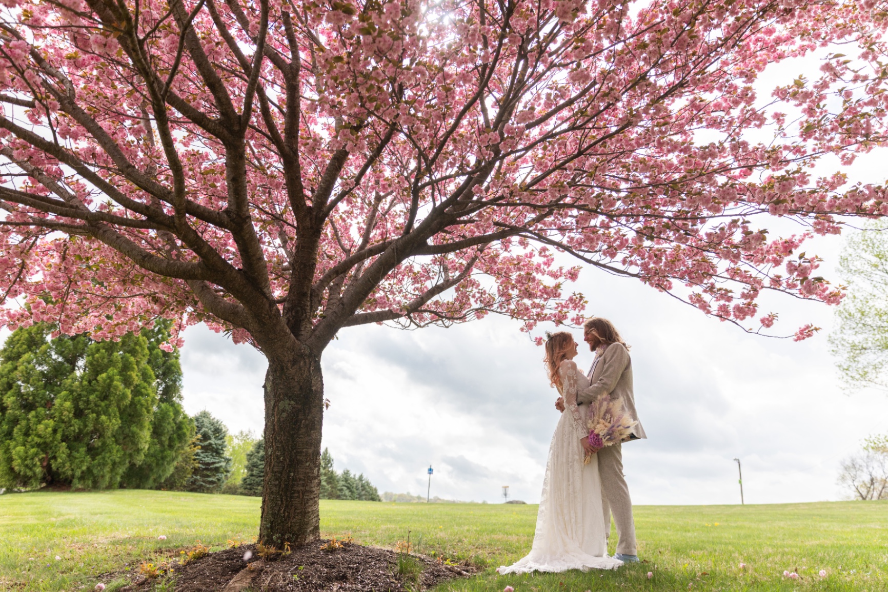 Dani & Kyle — embrace under blossoms at Bear Creek Mountain Resort