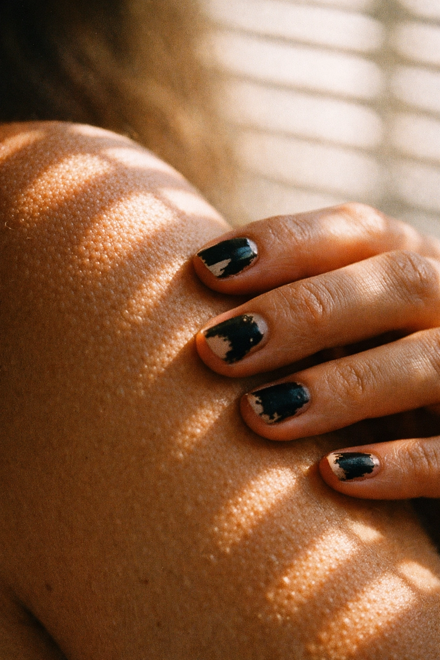 Close-up of a hand touching a bare arm to reconnect with physical skin sensations.
