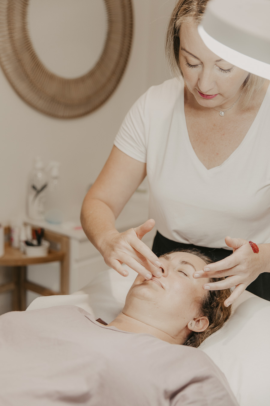 A beauty therapist at Allure Beauty & Skin Clinic performing a facial treatment