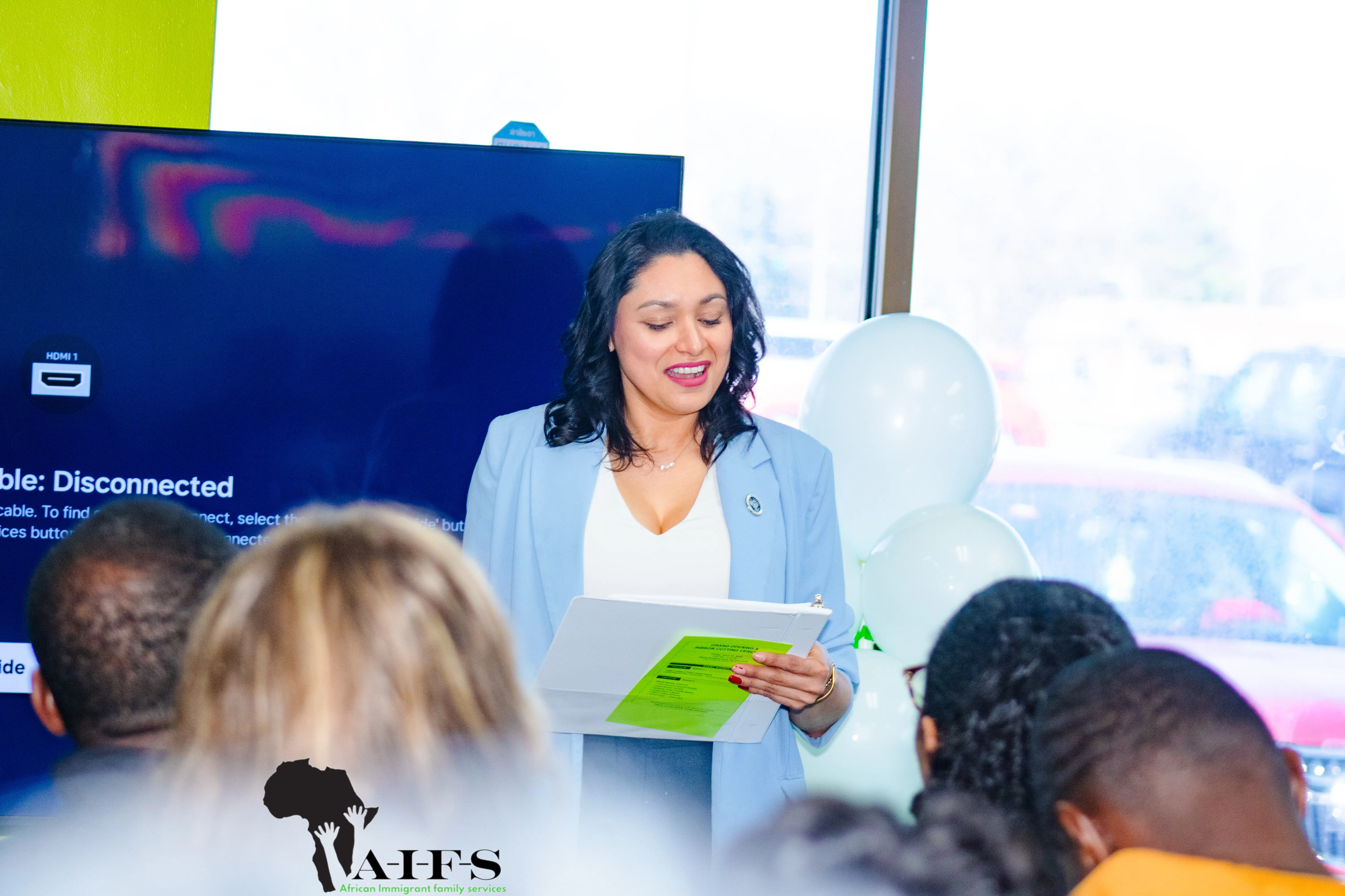 AIFS volunteer helping a community member access digital refugee services in Nebraska.