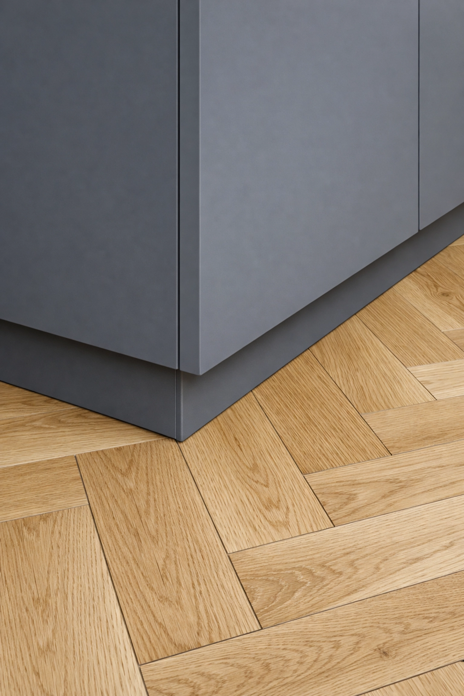 Modern kitchen island and herringbone flooring detail from a high-quality London home refurbishment.