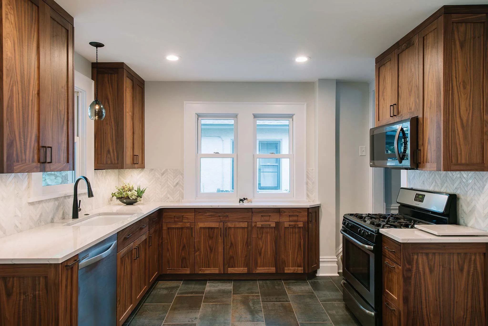Custom walnut cabinetry with shaker-style doors, soft-close drawers, and matte black hardware