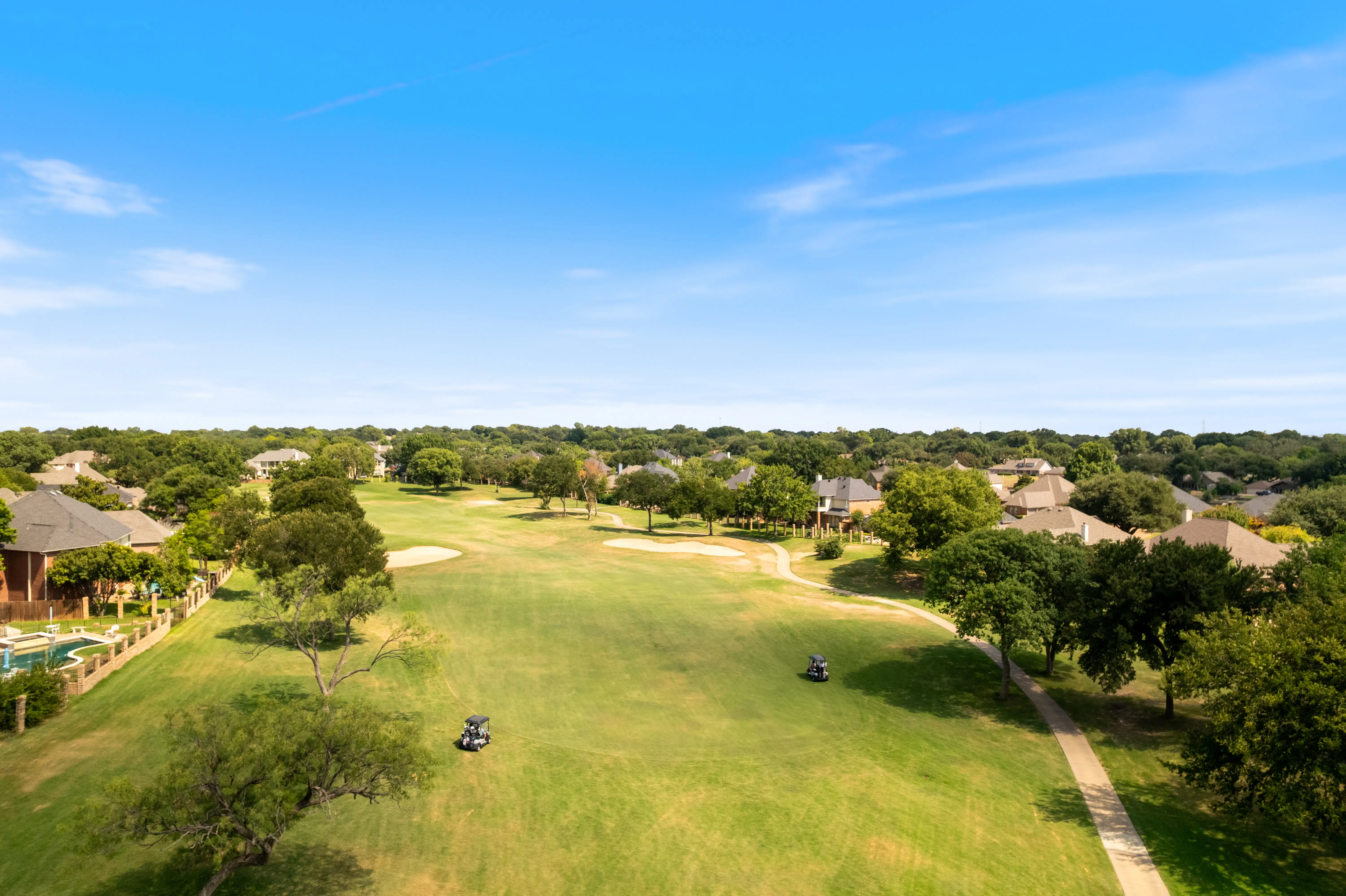 Aerial view of a scenic golf course surrounded by upscale residential homes