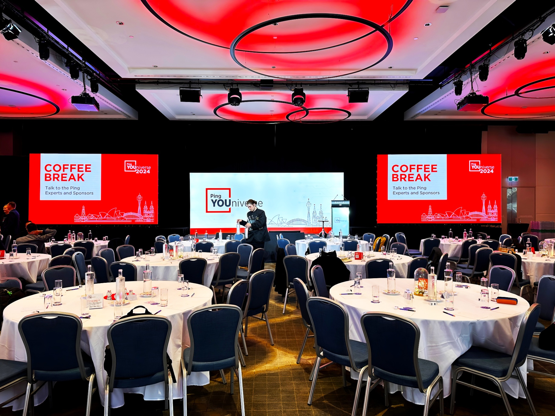 Conference setup with round tables and LED screens