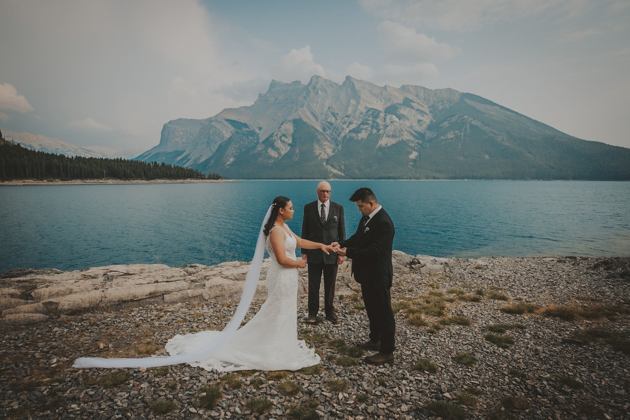 Bride and groom exchange rings at Lake Minnewanka
