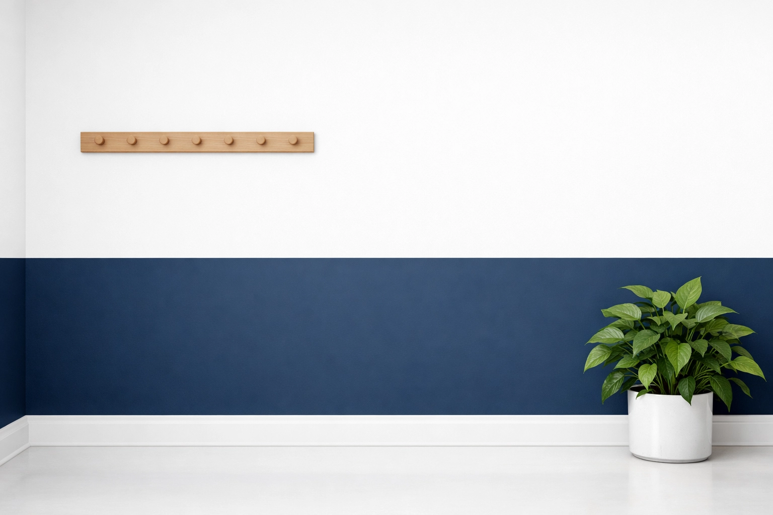 A modern hallway featuring a sharp horizontal split with navy blue and crisp white wall paint.