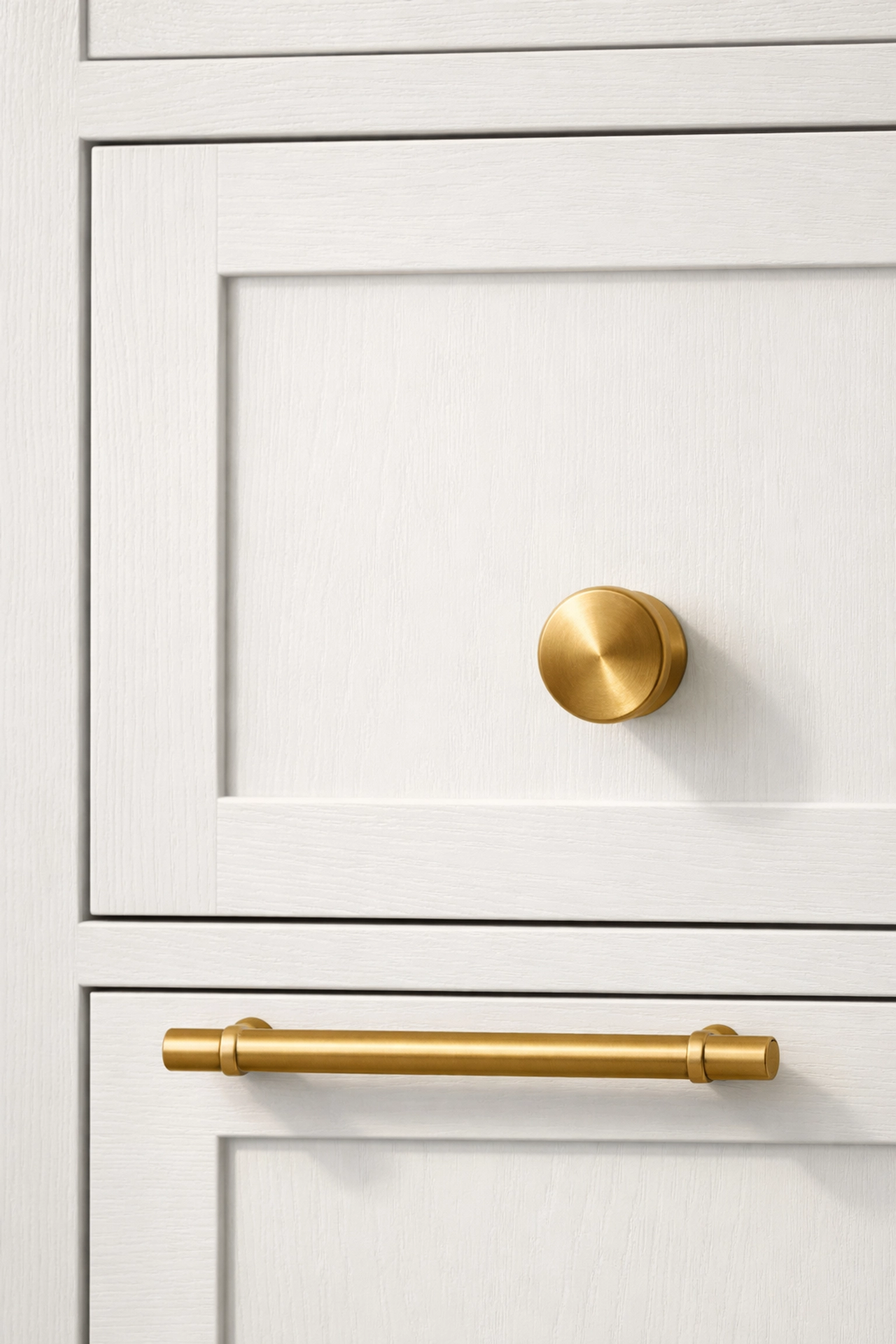 White Shaker-style cabinet door replacement with elegant brushed brass knob and bar pull hardware.