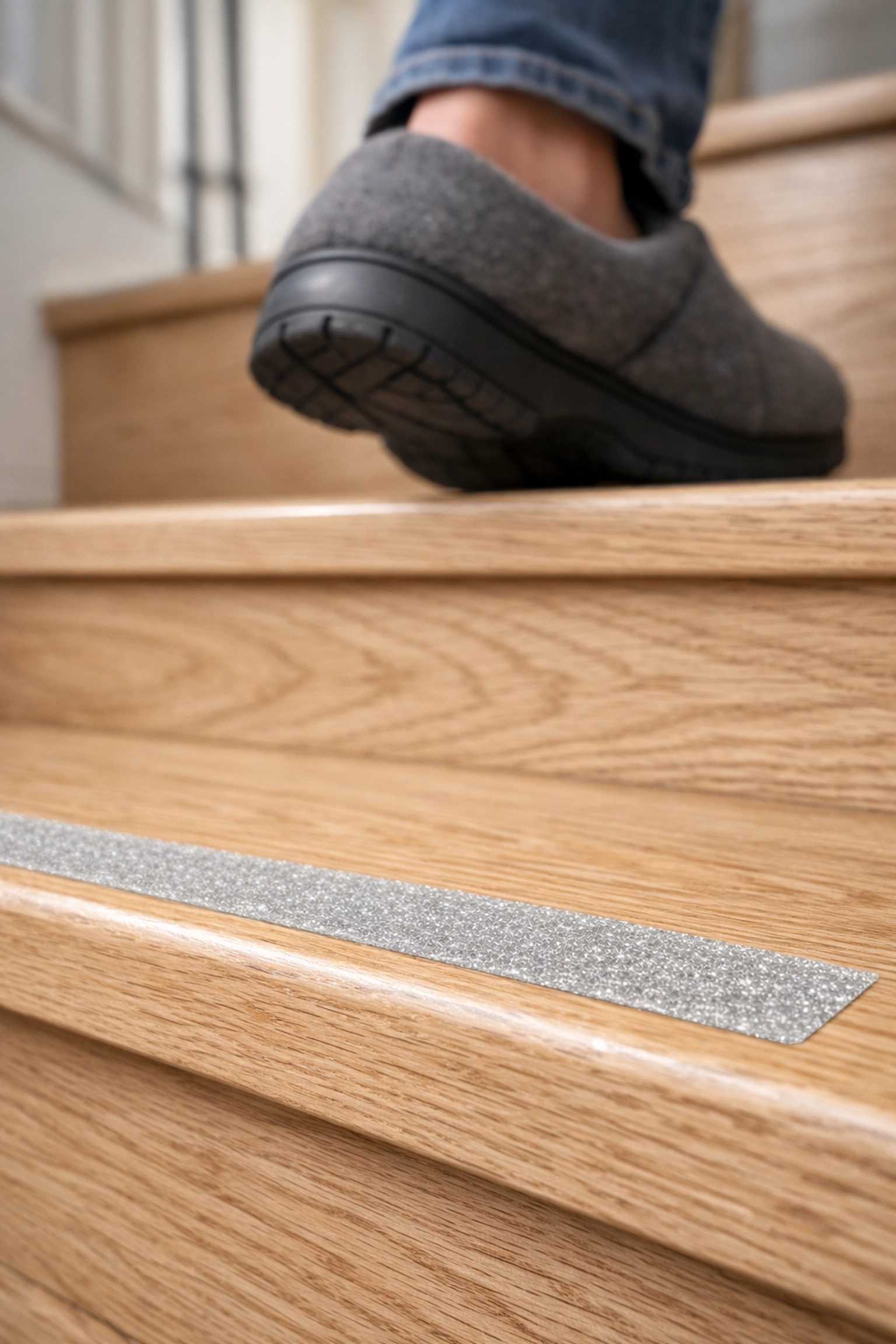 Wooden stairs with non-slip adhesive treads and a person wearing safe rubber-soled shoes.