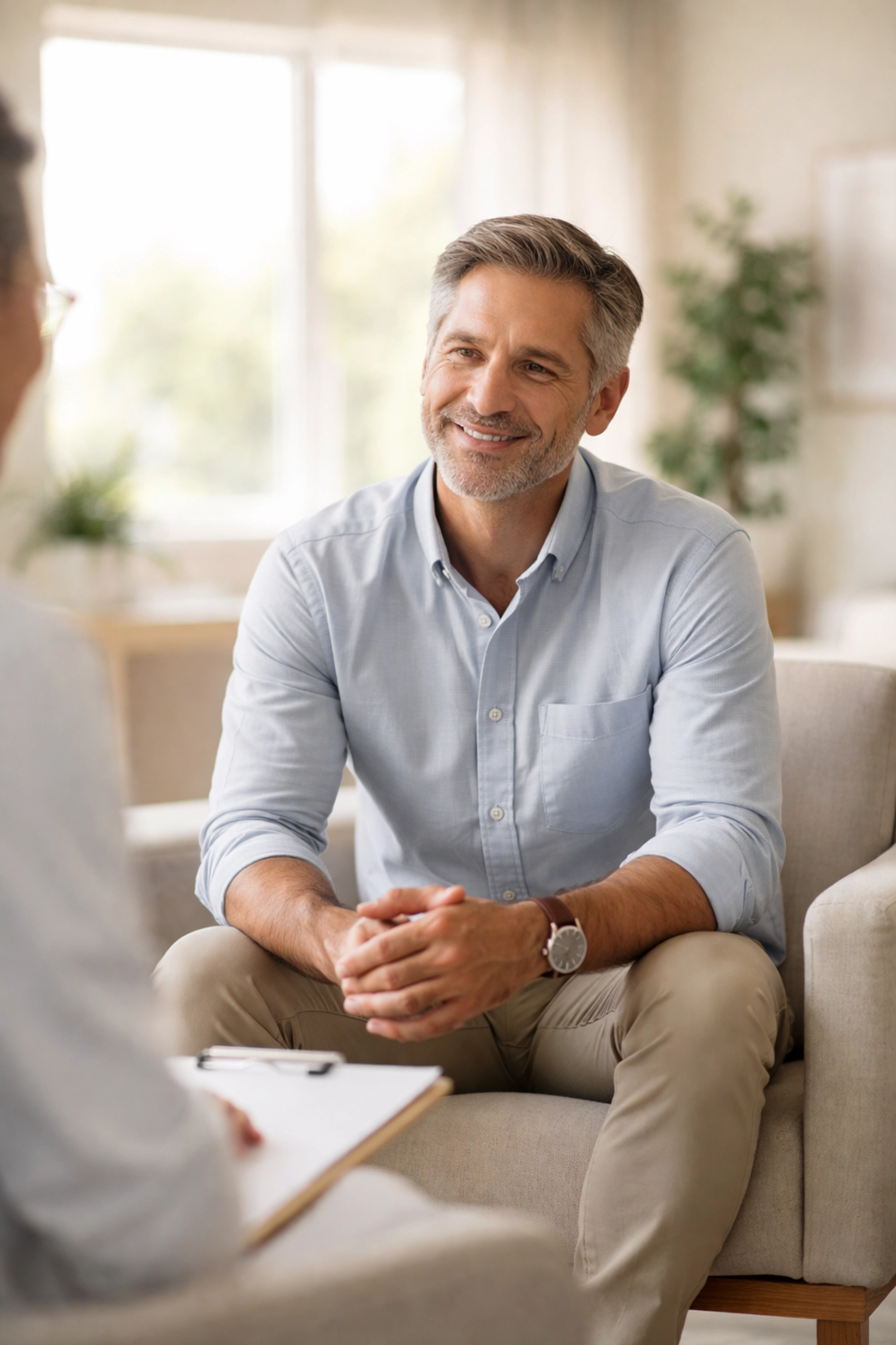 Middle-aged man confidently discussing men's sexual wellness with a provider in a modern Albuquerque clinic.