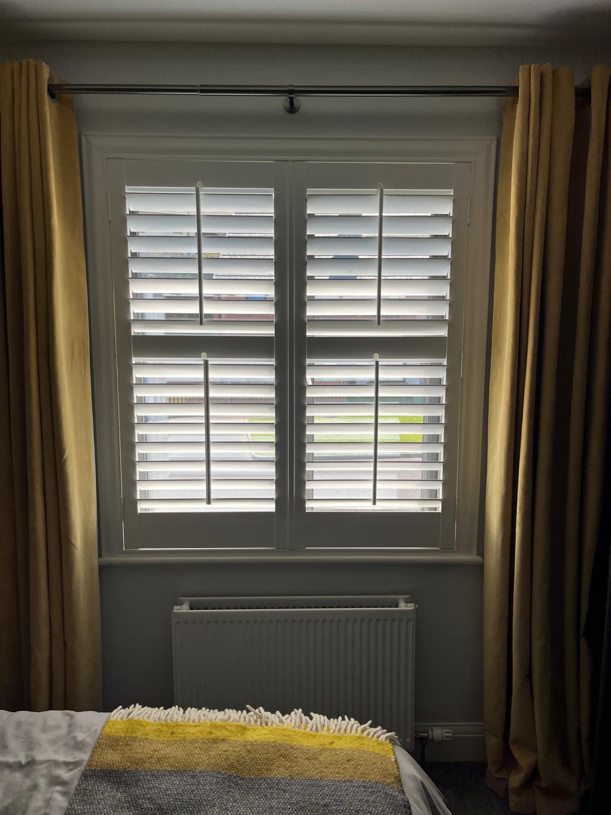 Premium custom-made white plantation shutters, precisely measured and professionally installed in a modern bedroom