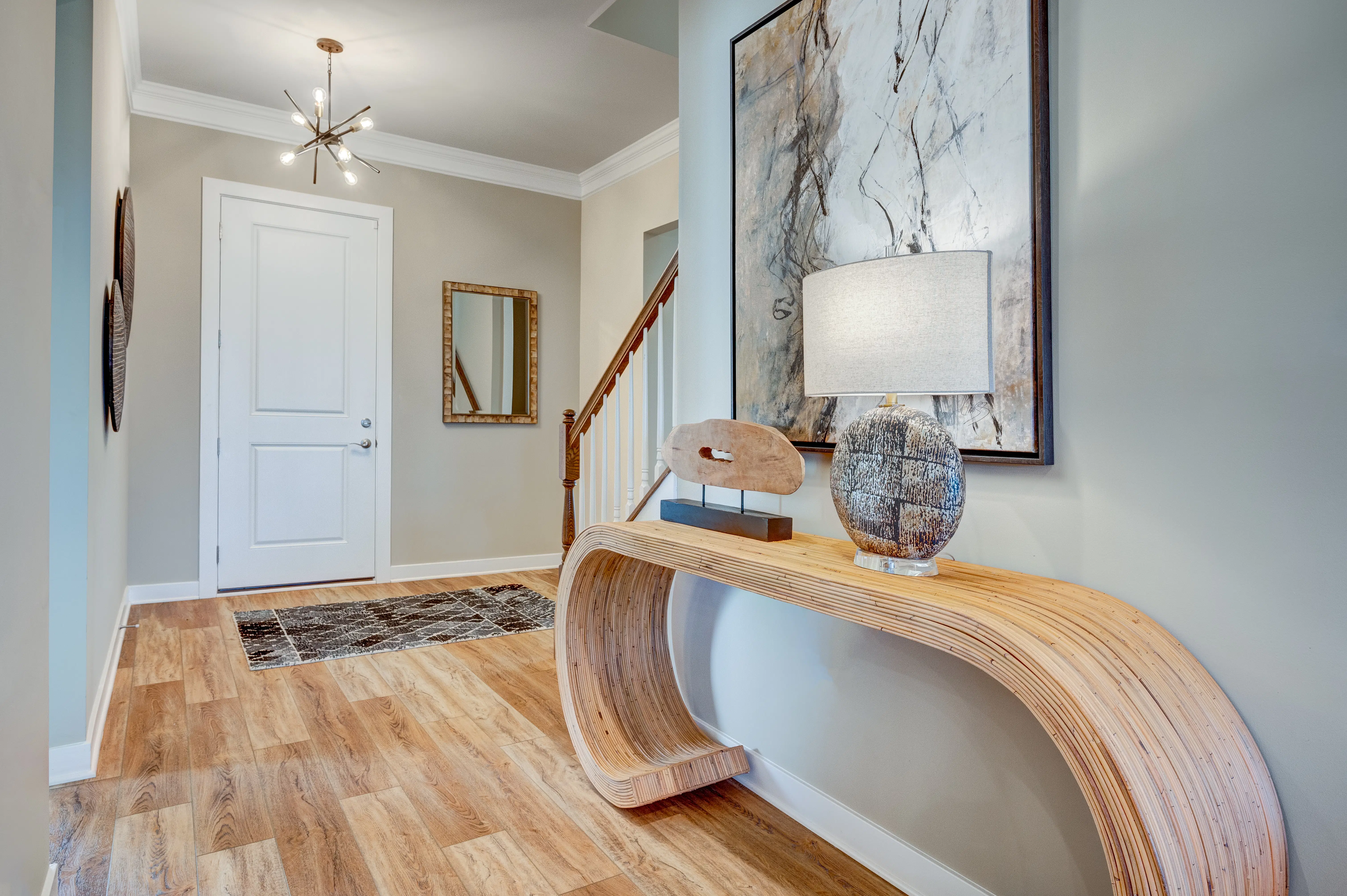 Modern entryway featuring natural wood flooring and sophisticated decor