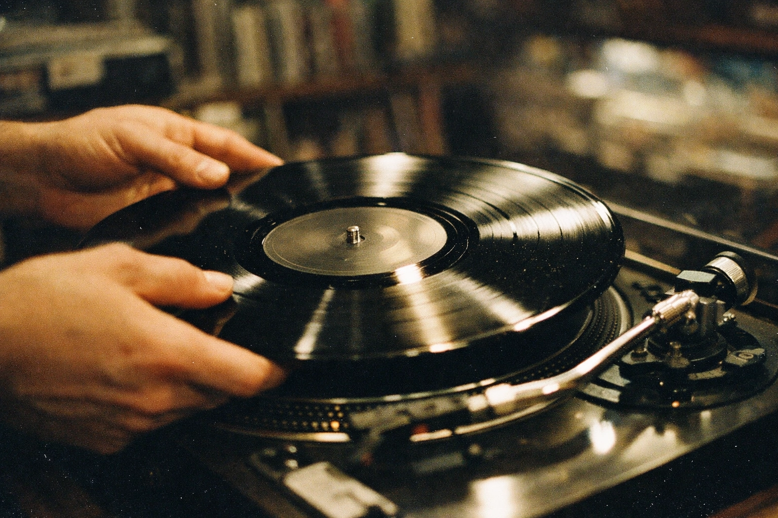 Hands placing a vinyl record on turntable to begin the listening ritual