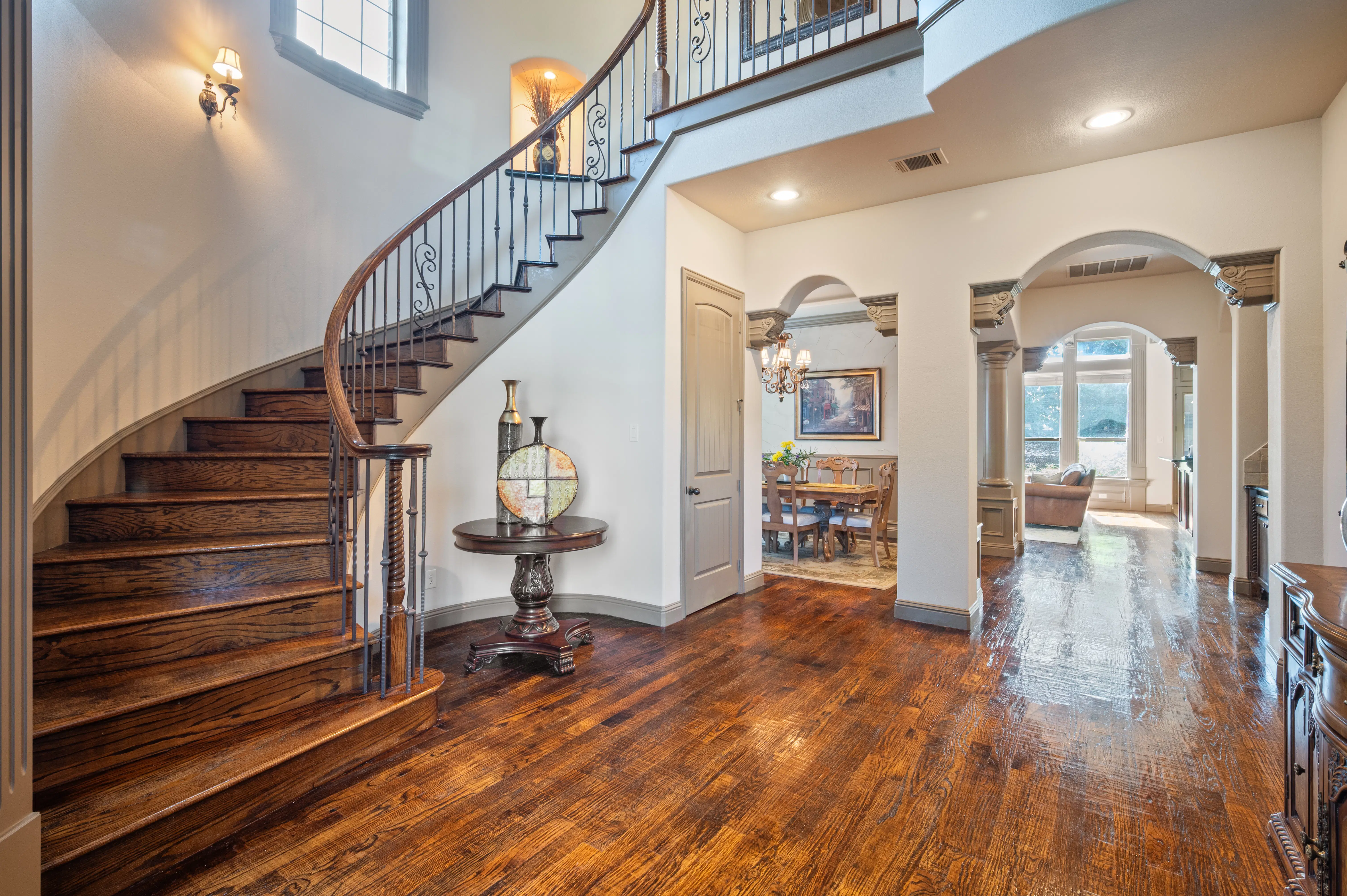 Elegant two-story foyer with grand curved hardwood staircase