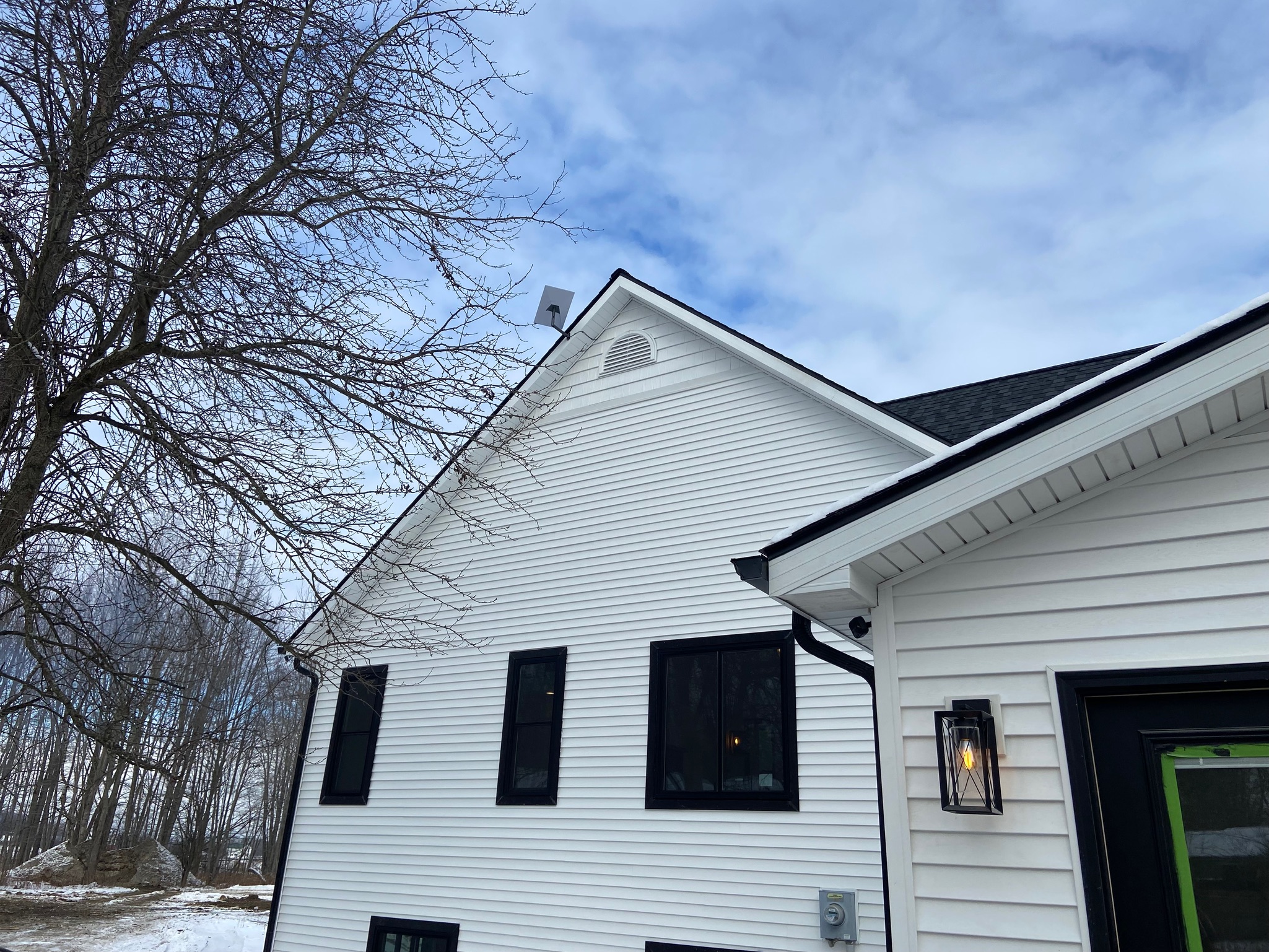 Starlink dish mounted on a white gable roof at a rural Michigan property, showing a clean professional installation designed for reliable coverage.