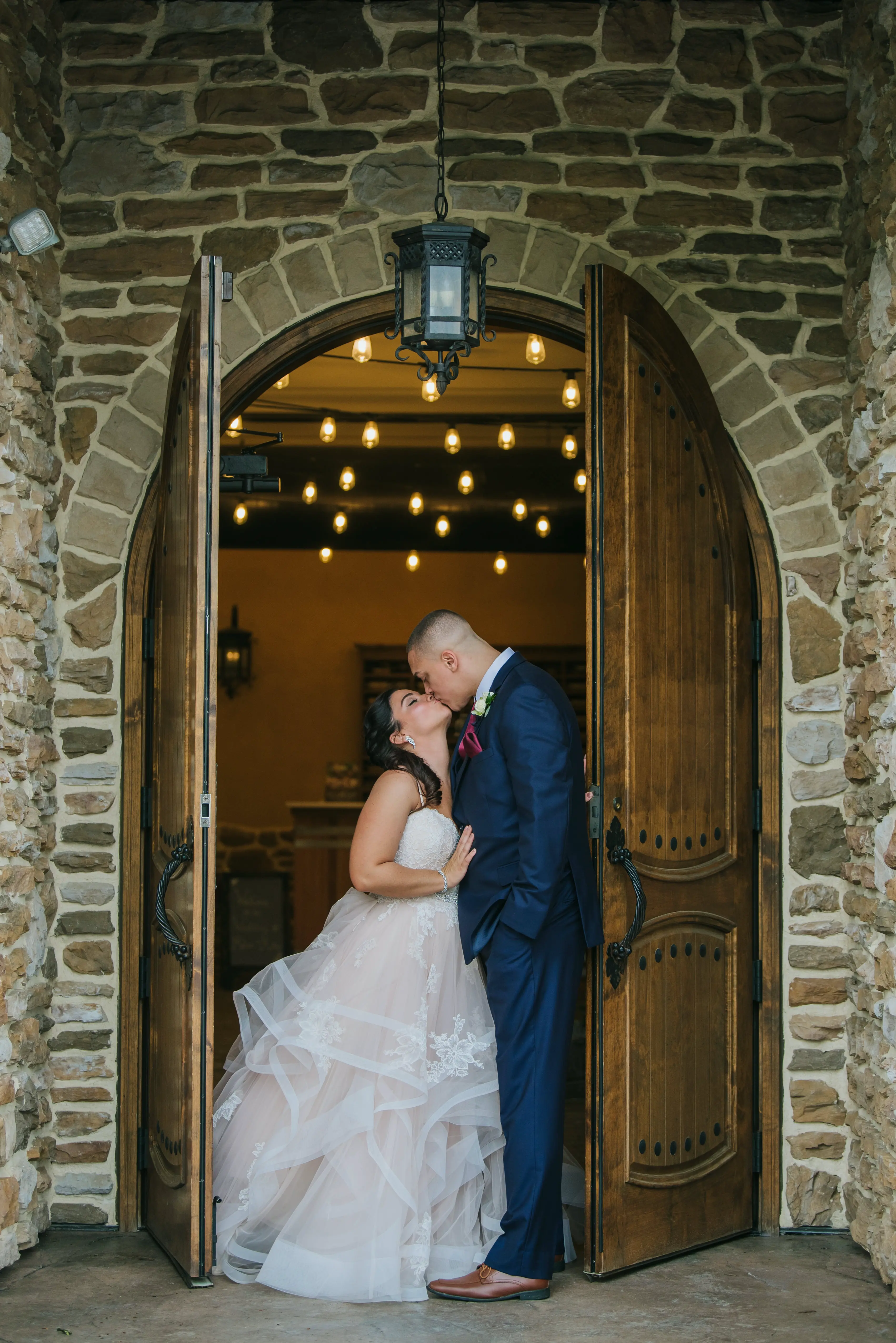 Bride and Groom Kiss in Rustic Doorway