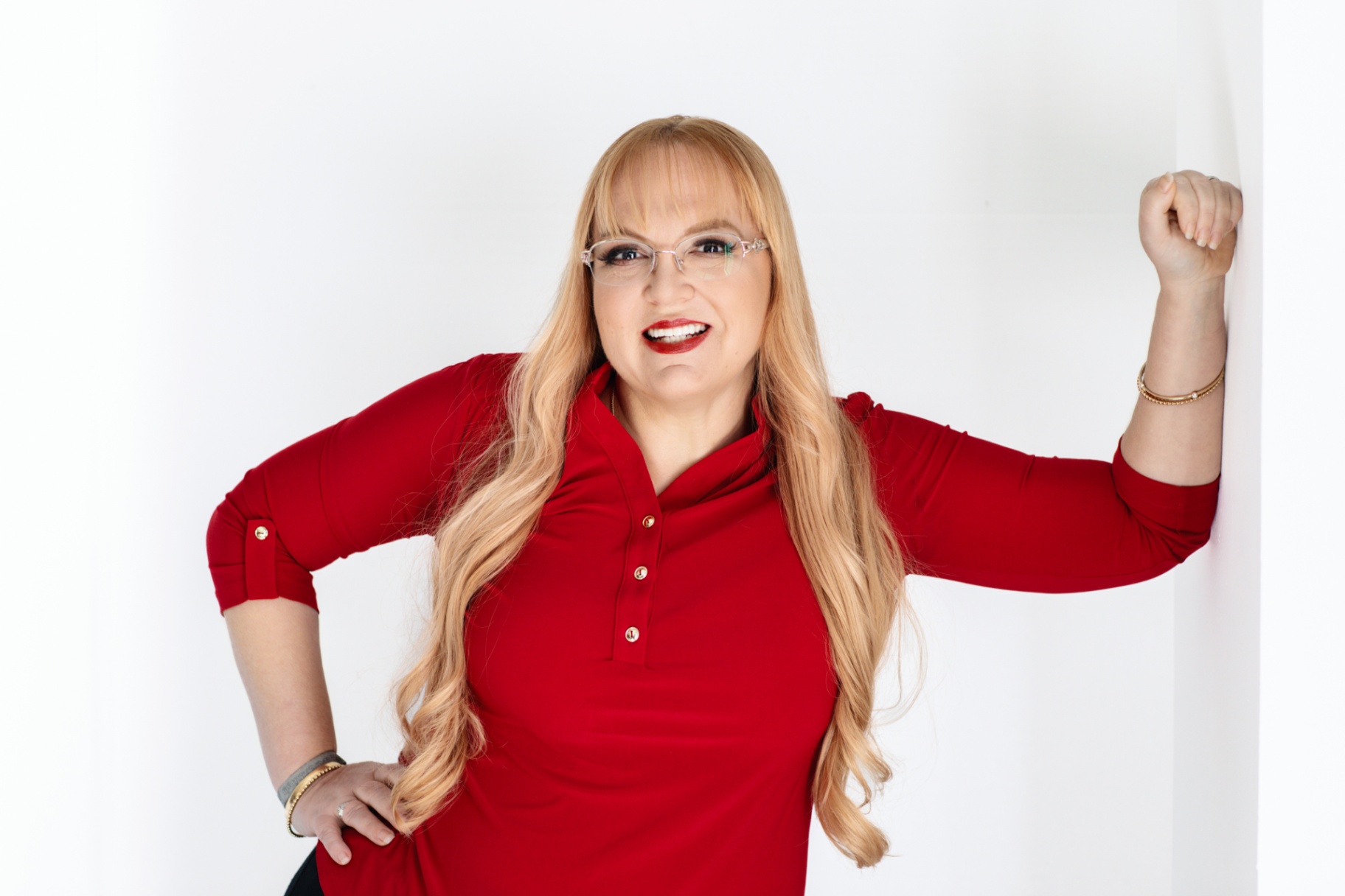 A friendly, approachable bookkeeping professional in a bright red shirt, smiling confidently against a plain white background.