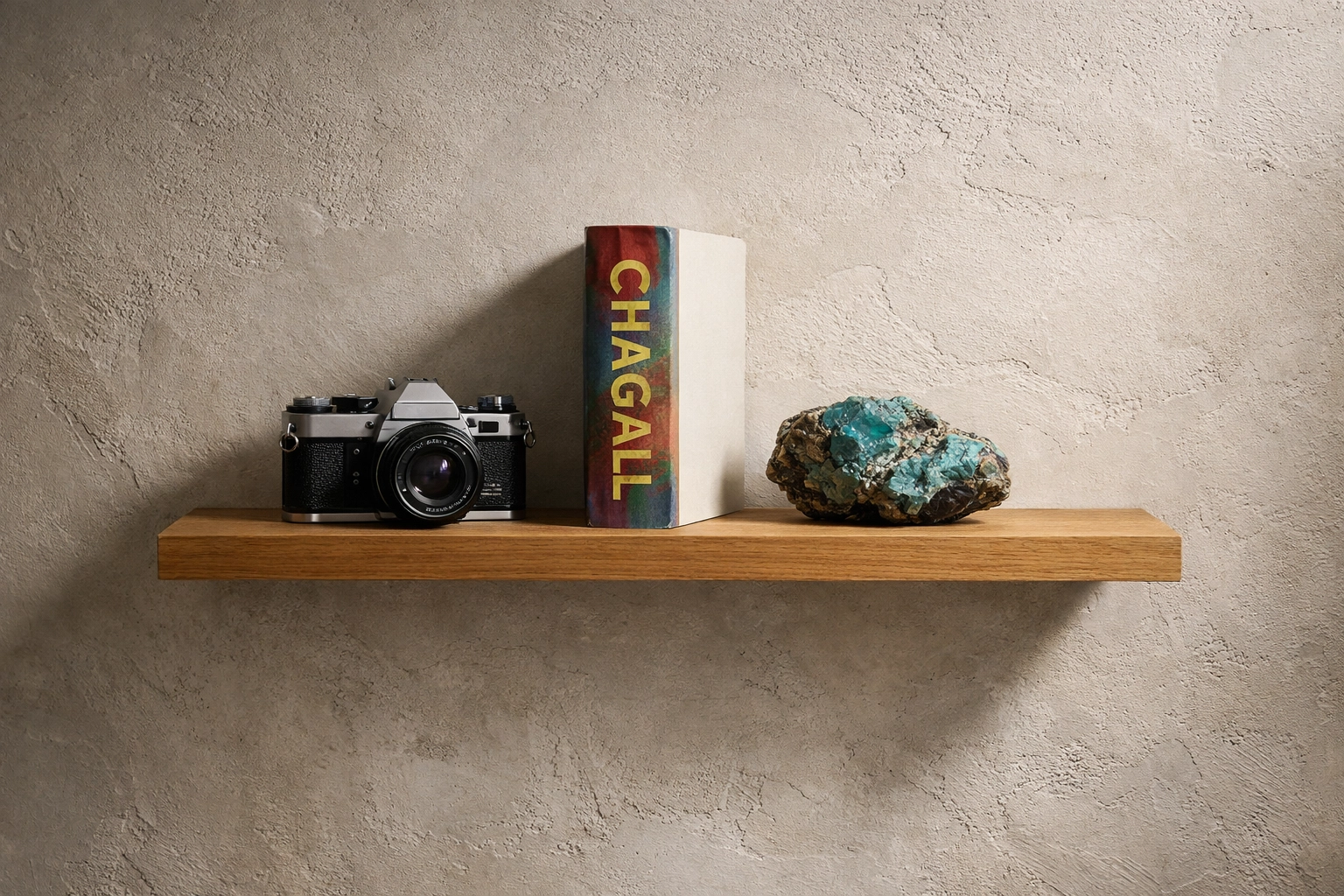 Curated shelf featuring a vintage camera, collectible art book, and turquoise stone in a boutique display.