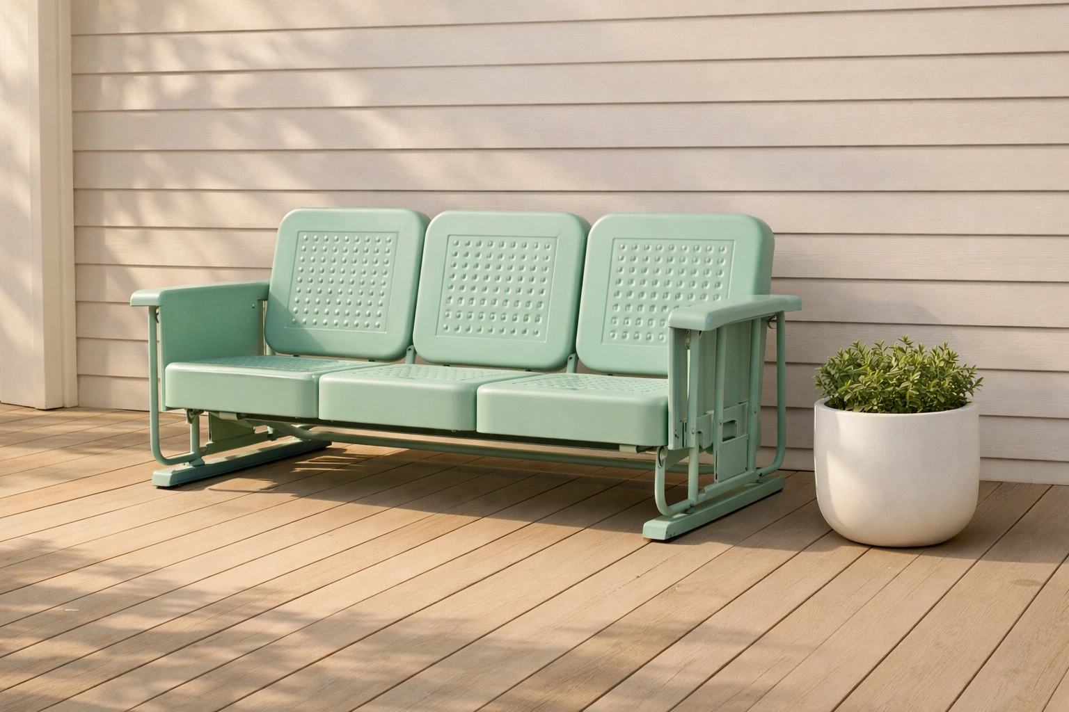 Mint green Crosley retro metal outdoor sofa glider on a modern wood patio deck.