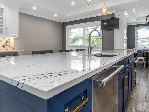 Contemporary kitchen remodel design with custom kitchen design details, custom cabinets, and a statement island with marble-look quartz countertops.
