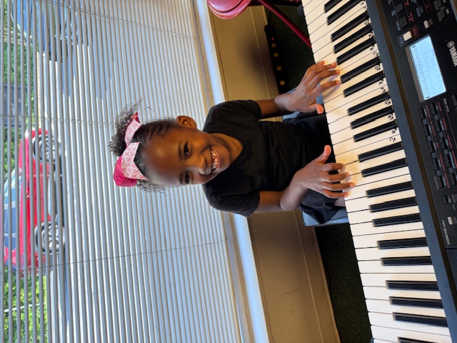 A young student at a digital piano lesson