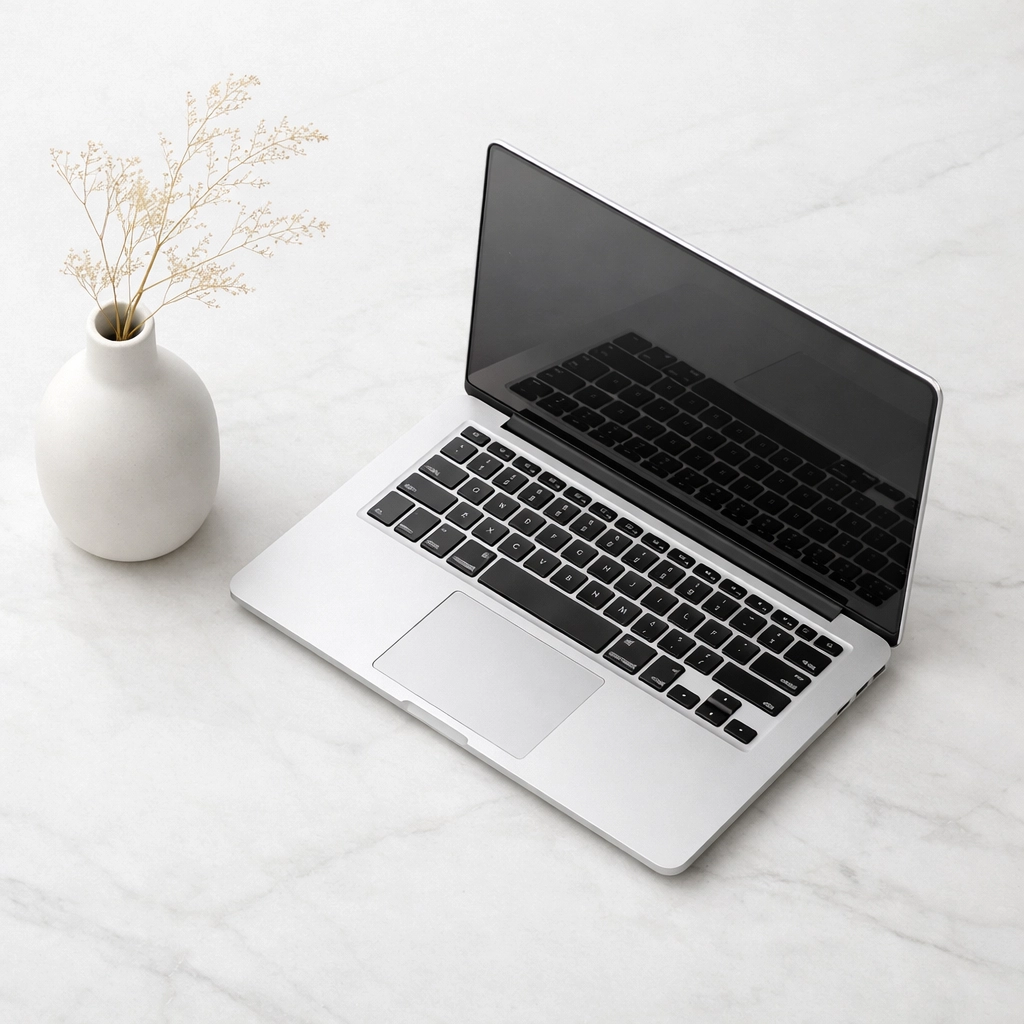 A minimalist workspace showing a laptop used to manage hotel channel manager and CRM integrations.