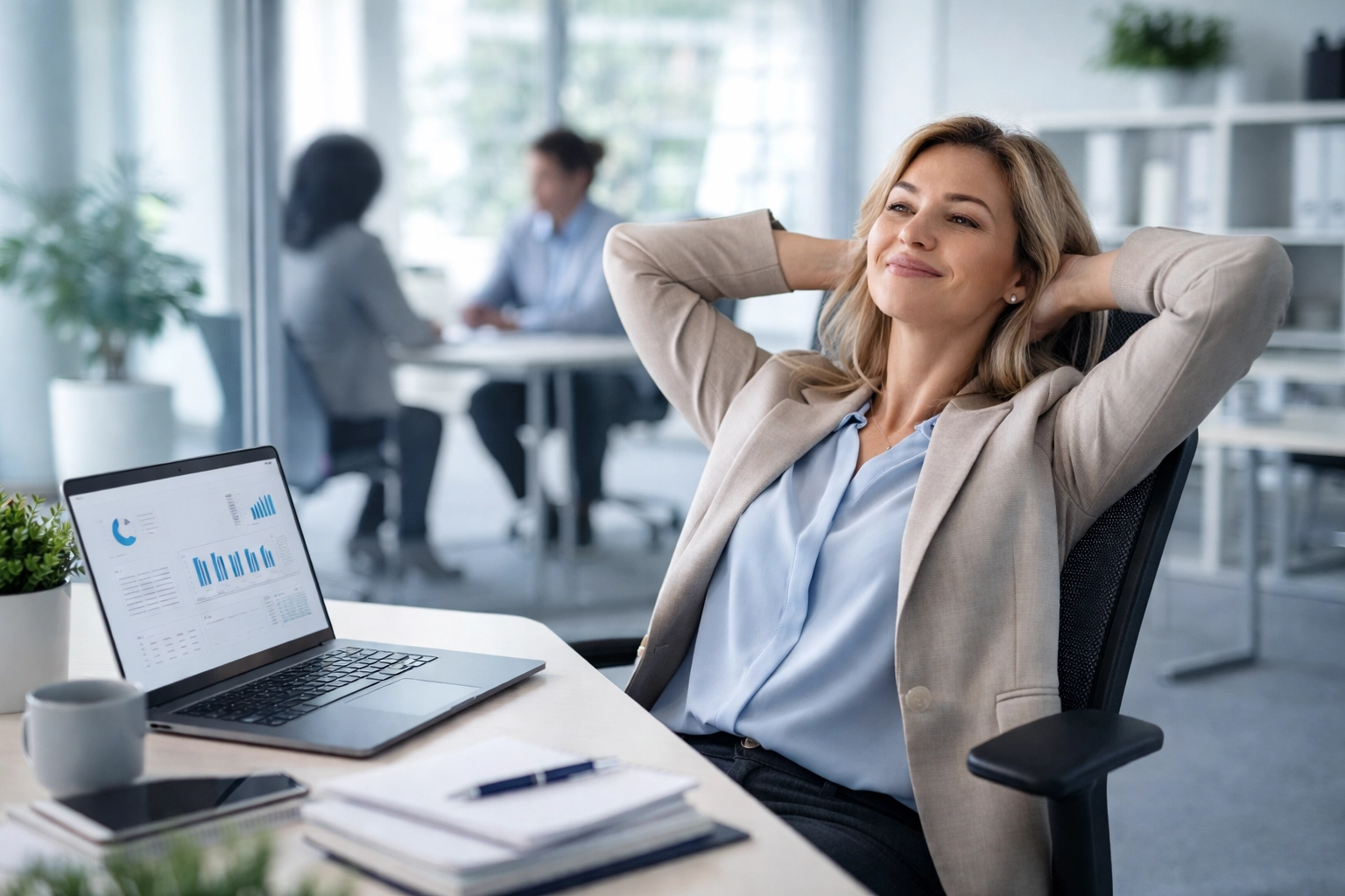 Relaxed HR professional while benefits counselor handles employee enrollment questions in background