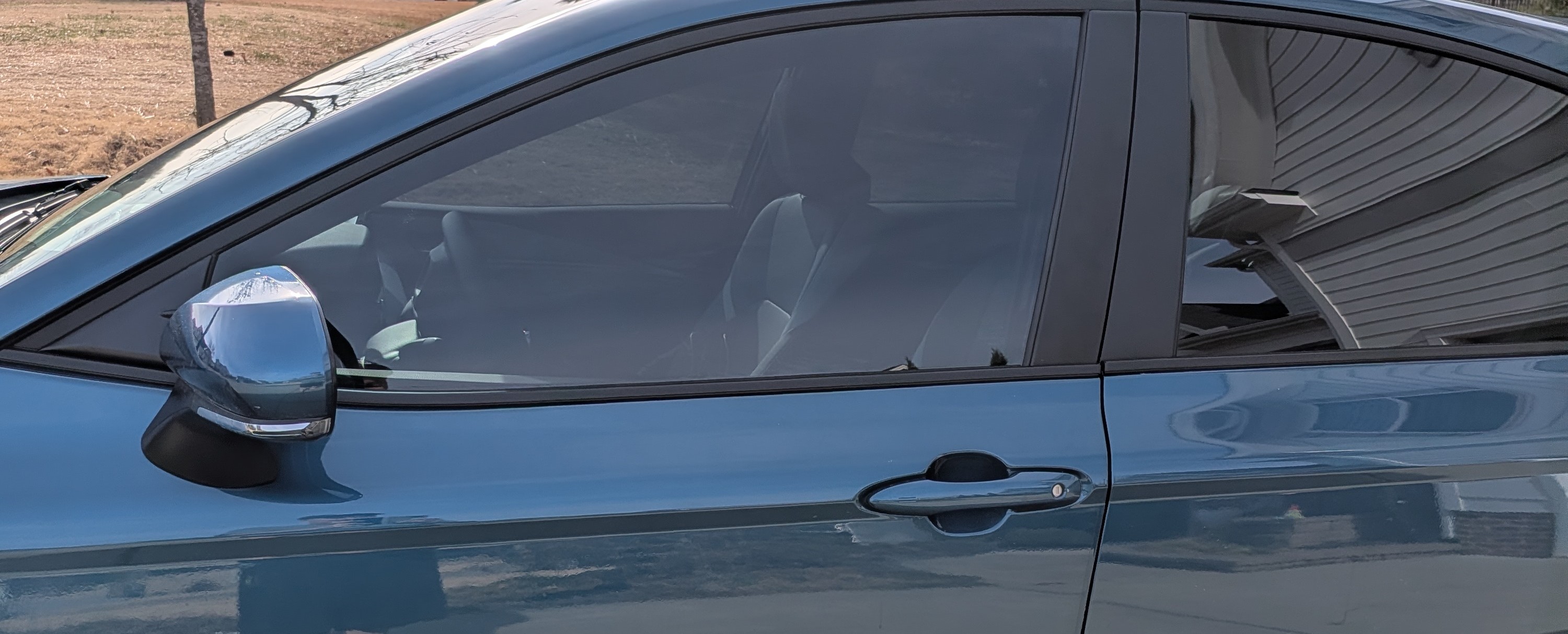 Professional Automotive Window Tint Installation on Blue Sedan
