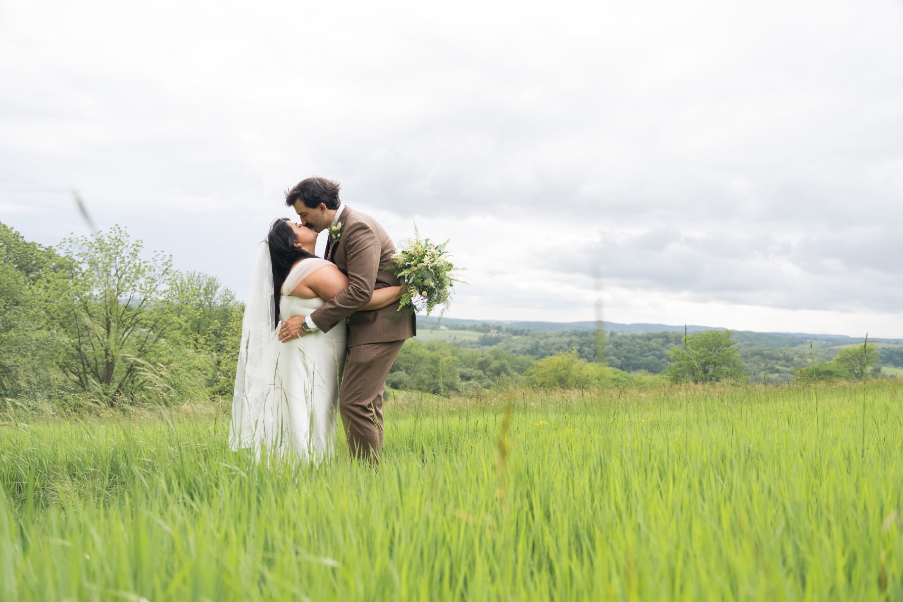 Bride and Groom Kiss in Green Field
