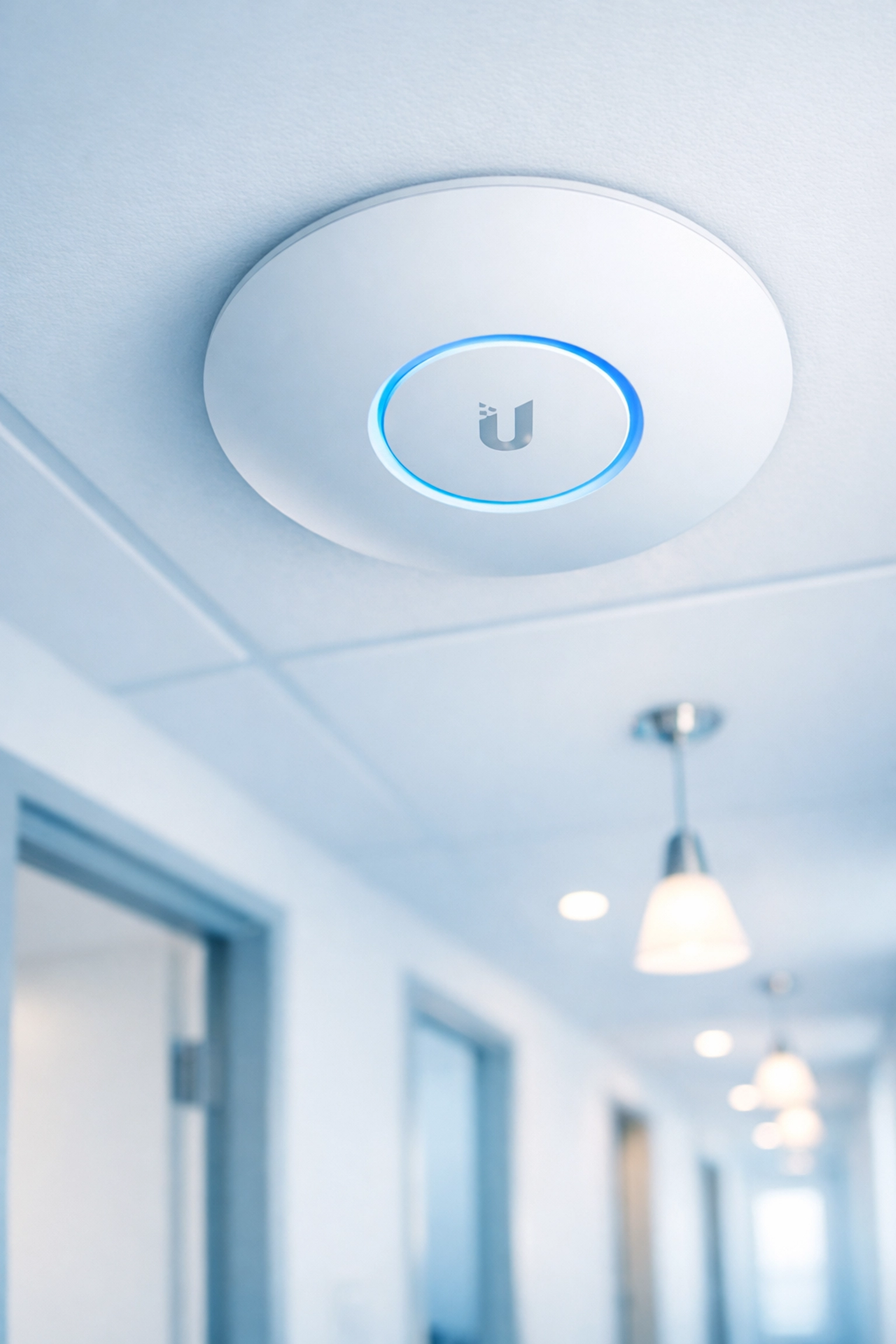 Ubiquiti UniFi access point mounted on ceiling in student accommodation corridor
