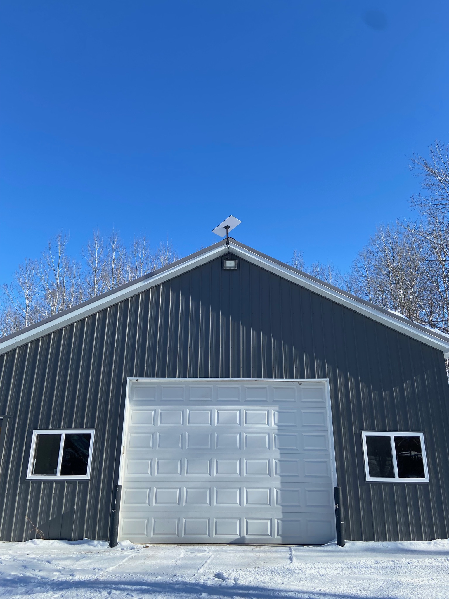 Starlink dish mounted on a gray steel barn in rural Michigan, showing a clean professional installation suited for large agricultural properties.