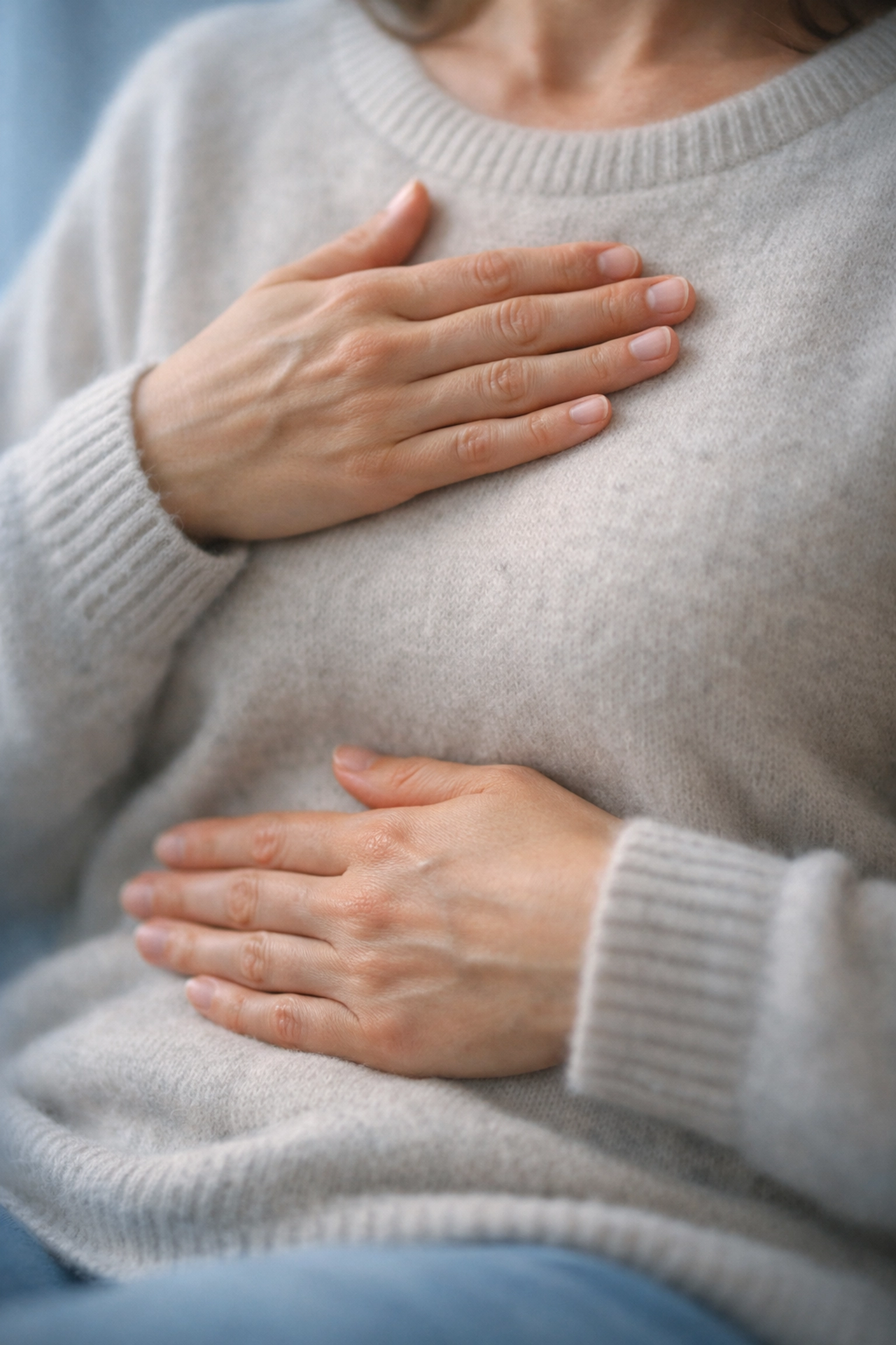 Hands placed on chest demonstrating breathing technique for nervous system regulation and emotional grounding